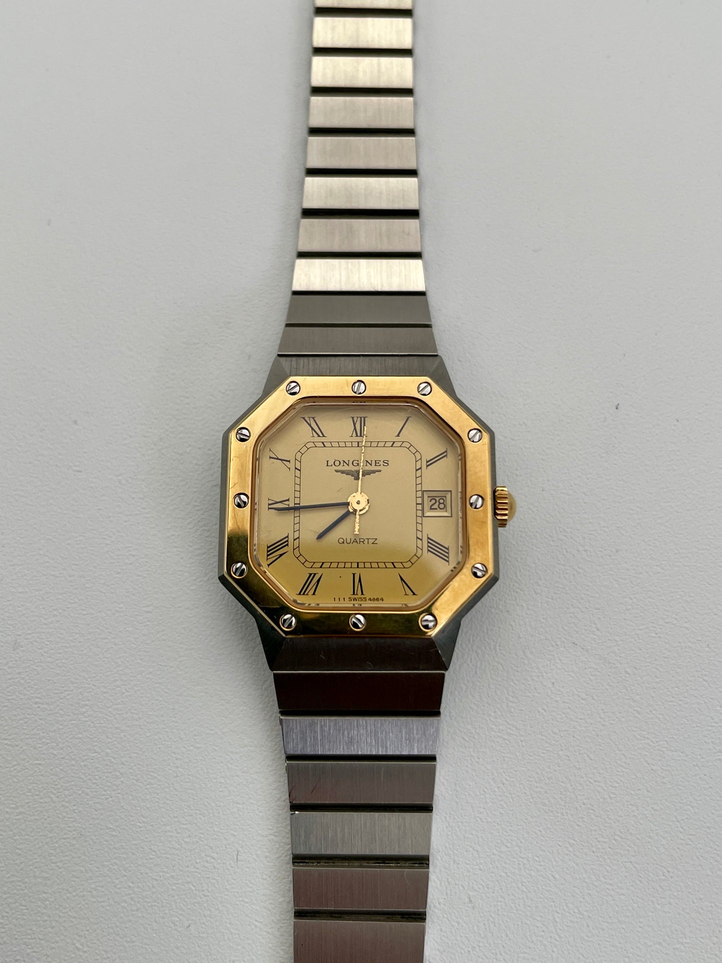 Front view of a 1980s Longines Octagon "Royal Oak" ladies quartz watch, featuring a gold-tone dial with Roman numeral markers and bezel screws.