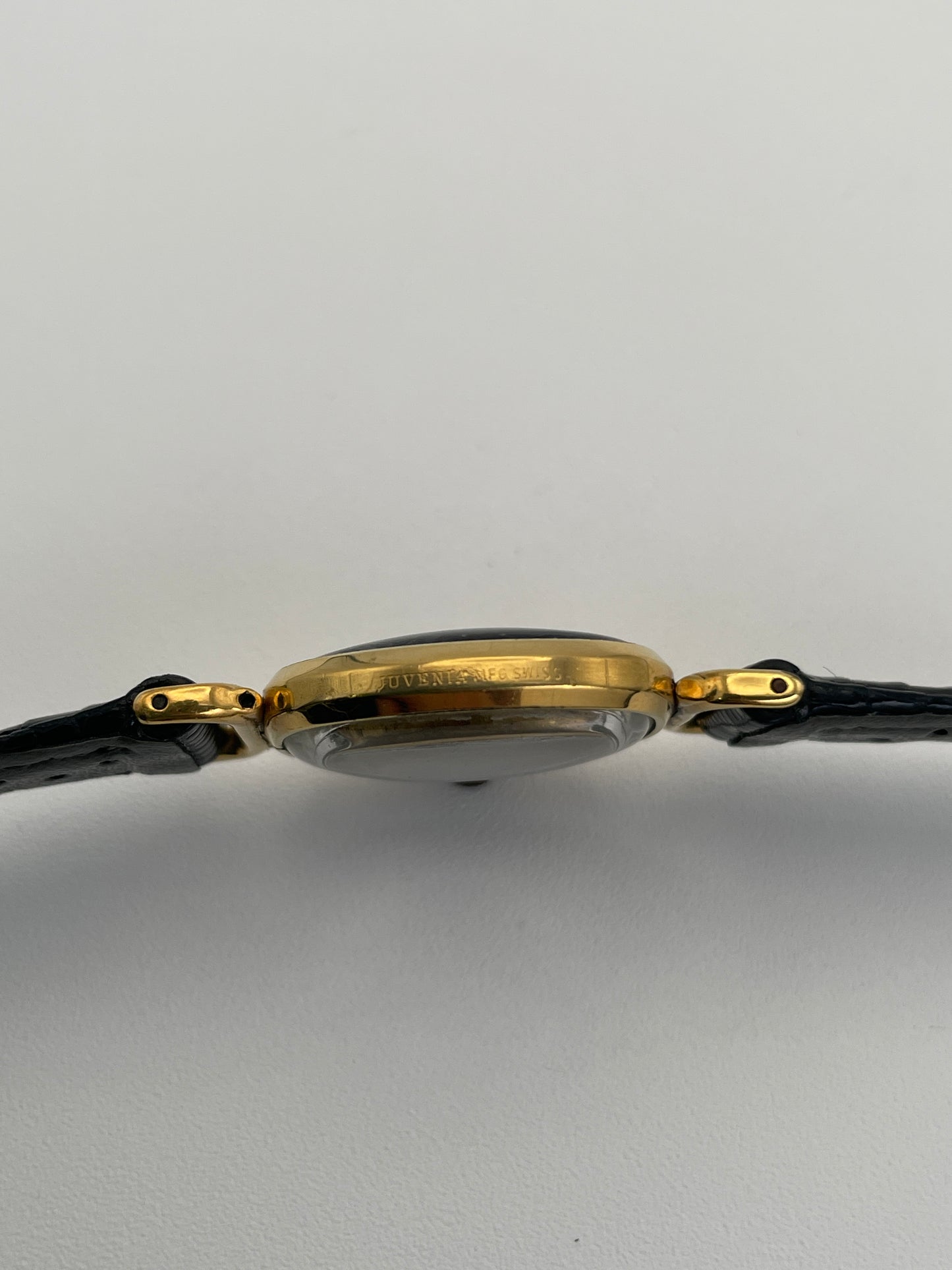 Side view of Juvenia Mystere Skeleton Watch focusing on the gold case and Juvenia case engravings.