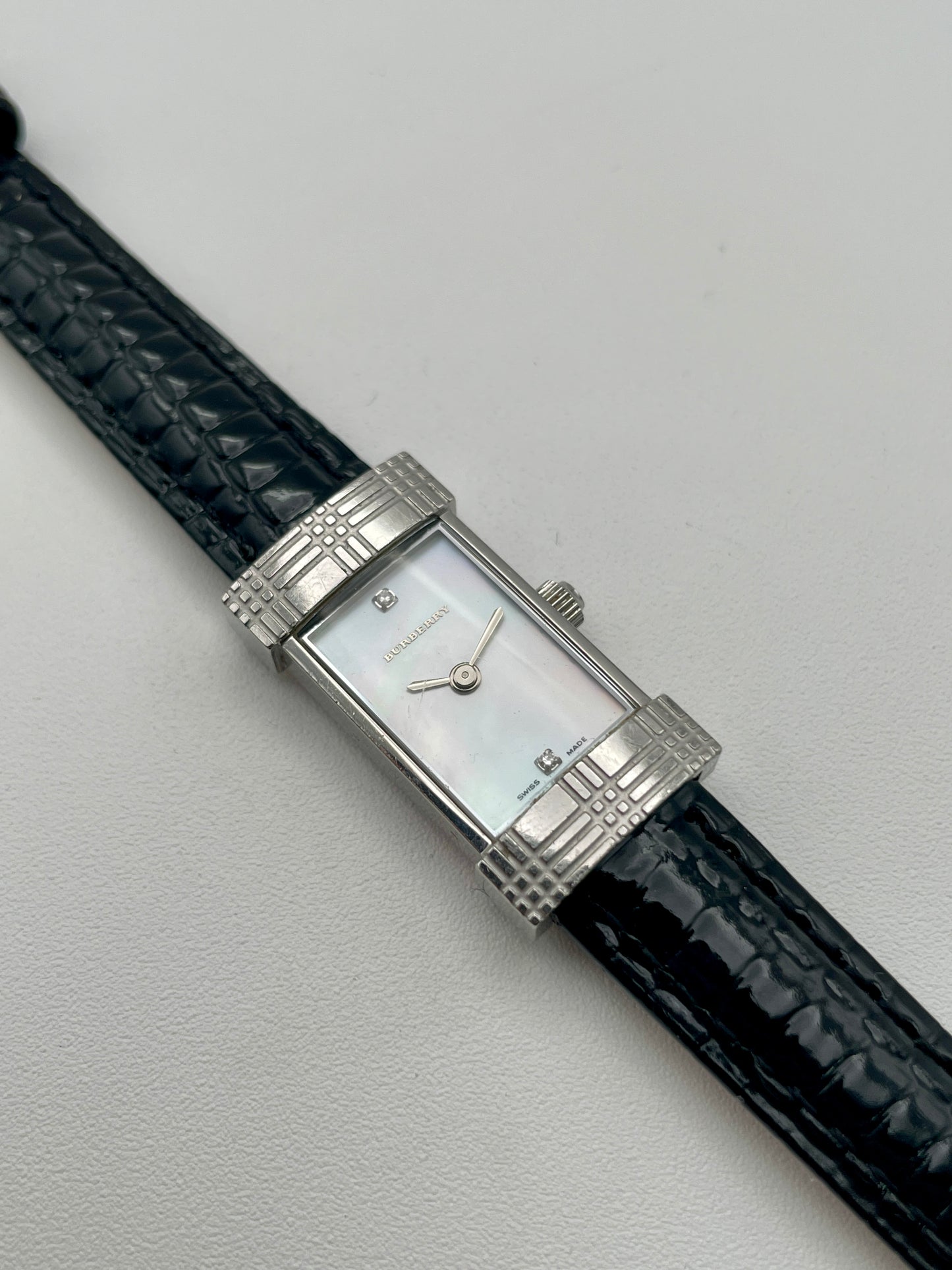Angled front view of Burberry vintage watch with mother-of-pearl dial and signature check bezel design