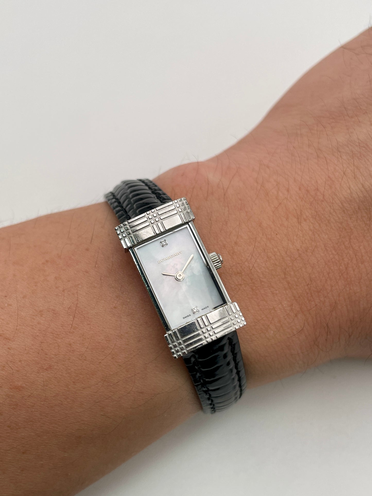 Wrist shot of the Burberry vintage watch with black strap and mother-of-pearl dial