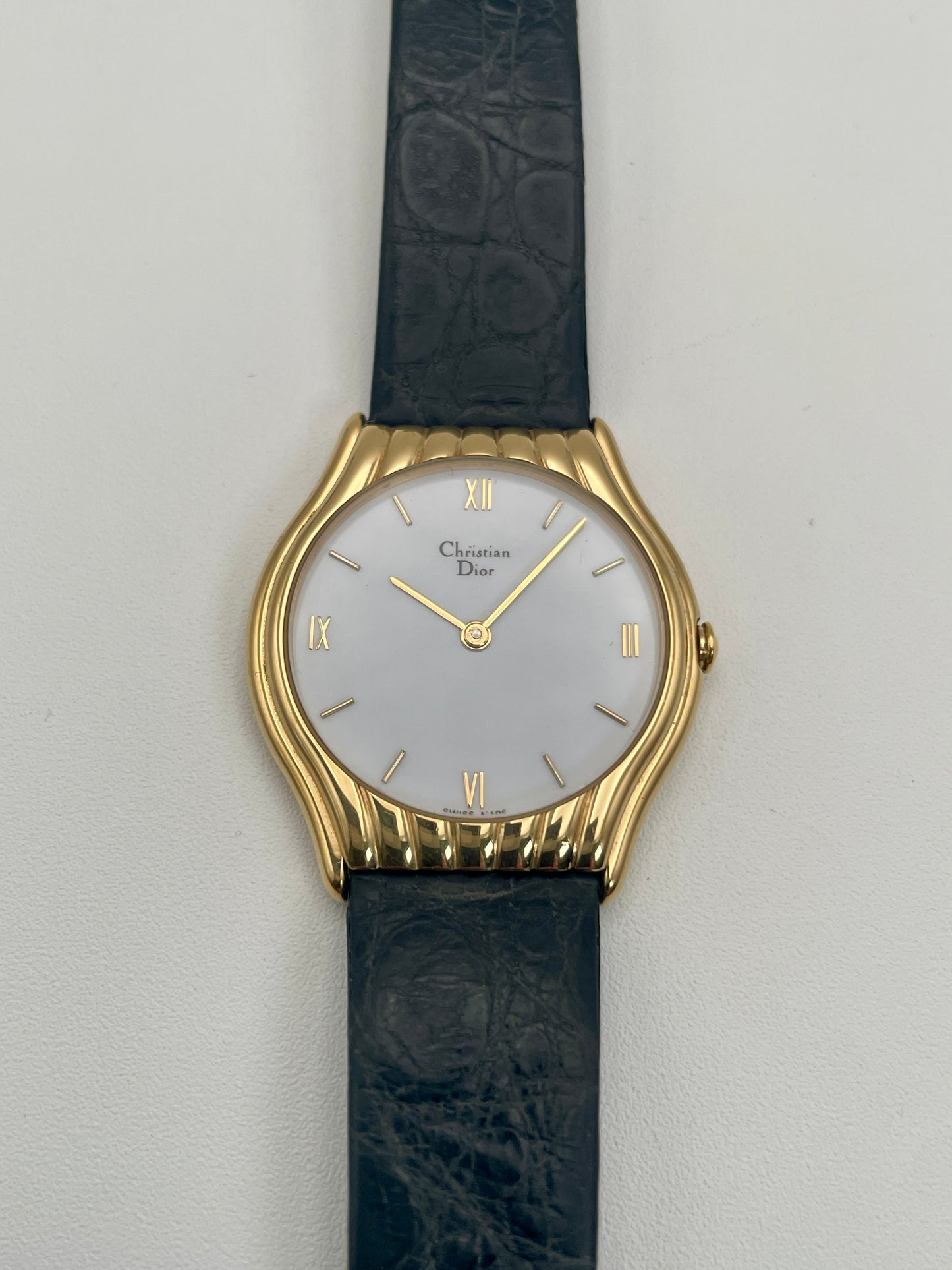 Front view of Christian Dior 3049 vintage women's watch featuring a gold case, mother-of-pearl dial, and black leather strap.