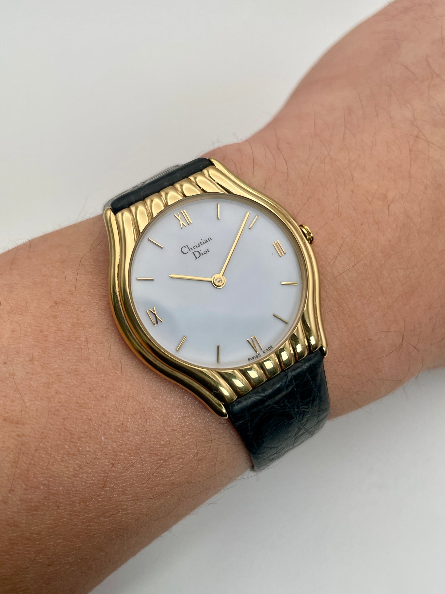 Christian Dior 3049 vintage women's watch worn on the wrist, highlighting the gold-tone case and black leather strap.
