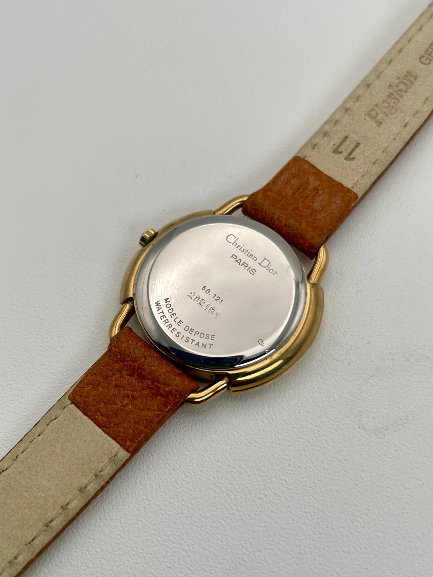 Caseback view of Christian Dior 58.121 vintage ladies watch, showing model and serial numbers with leather strap.