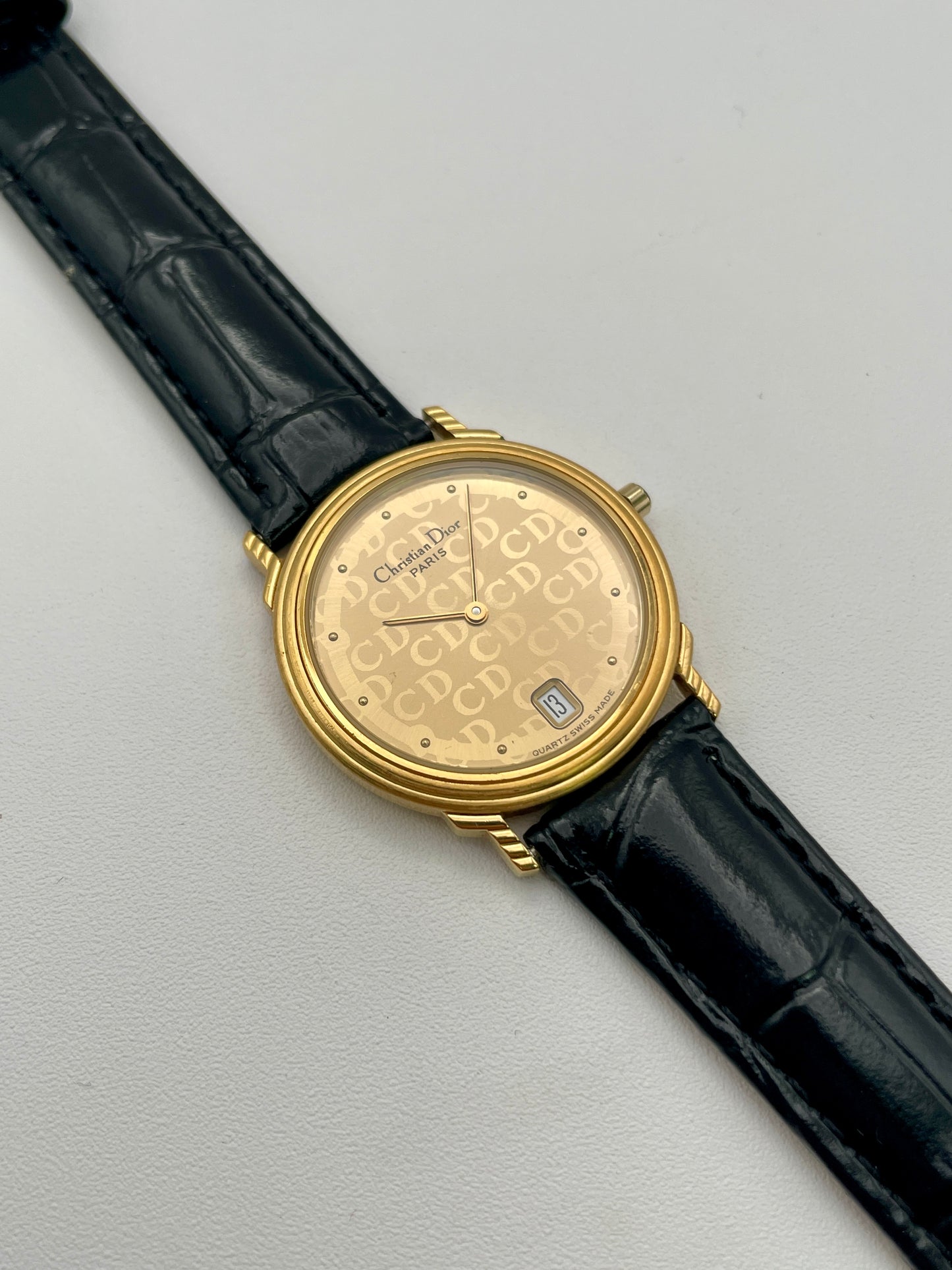 Christian Dior 45.122 vintage women's watch in gold-tone case with CD monogram dial and black leather strap, front view