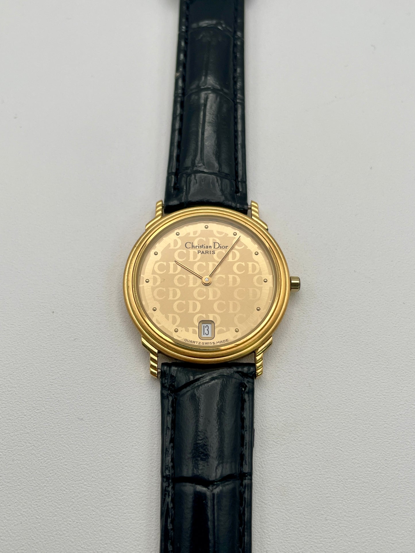 Christian Dior 45.122 vintage women's watch in gold-tone case with CD monogram dial and black leather strap, front view