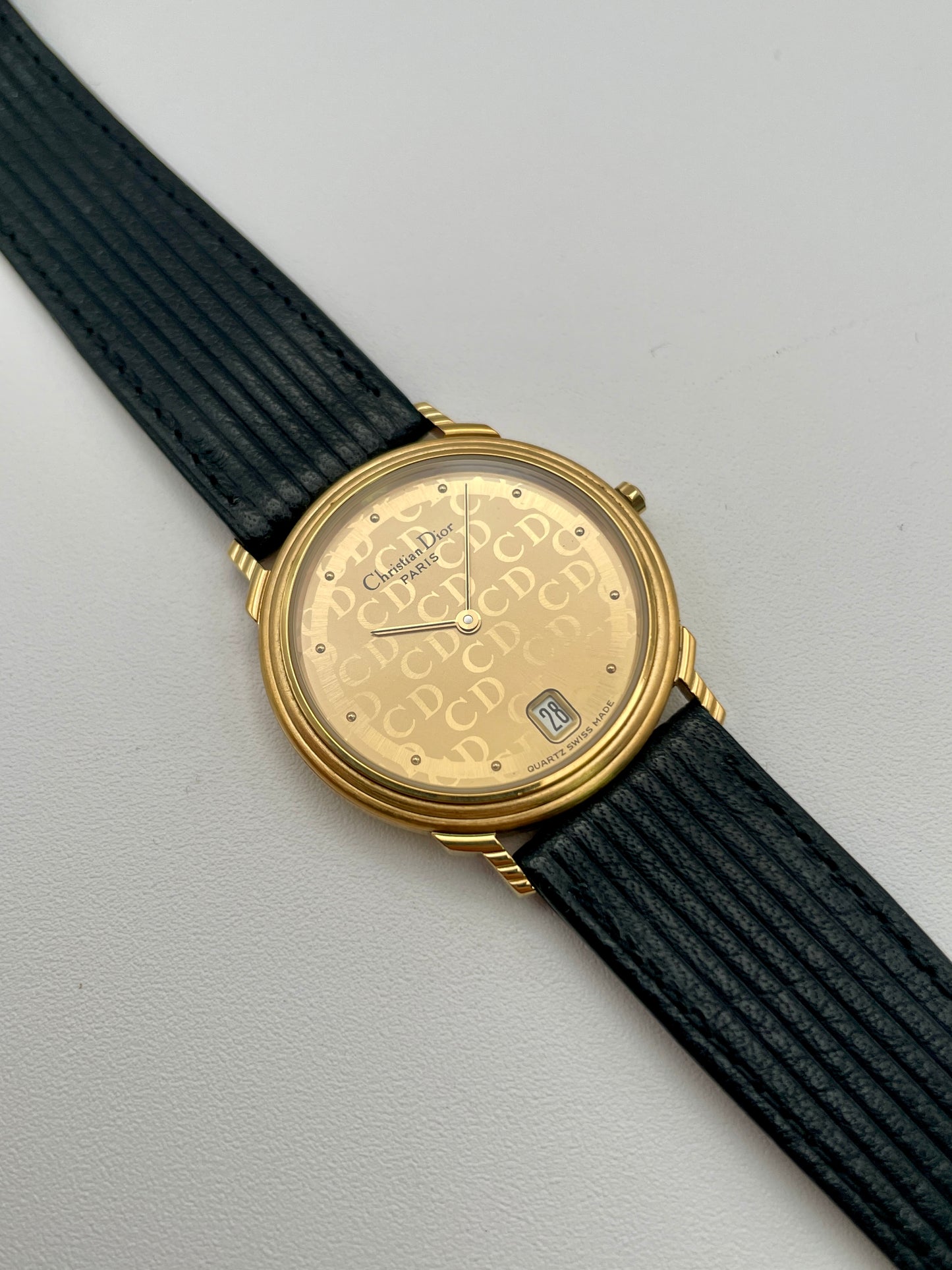 Christian Dior 45.122 vintage women's watch in gold with monogram dial and black ribbed strap, shown inside original Dior box
