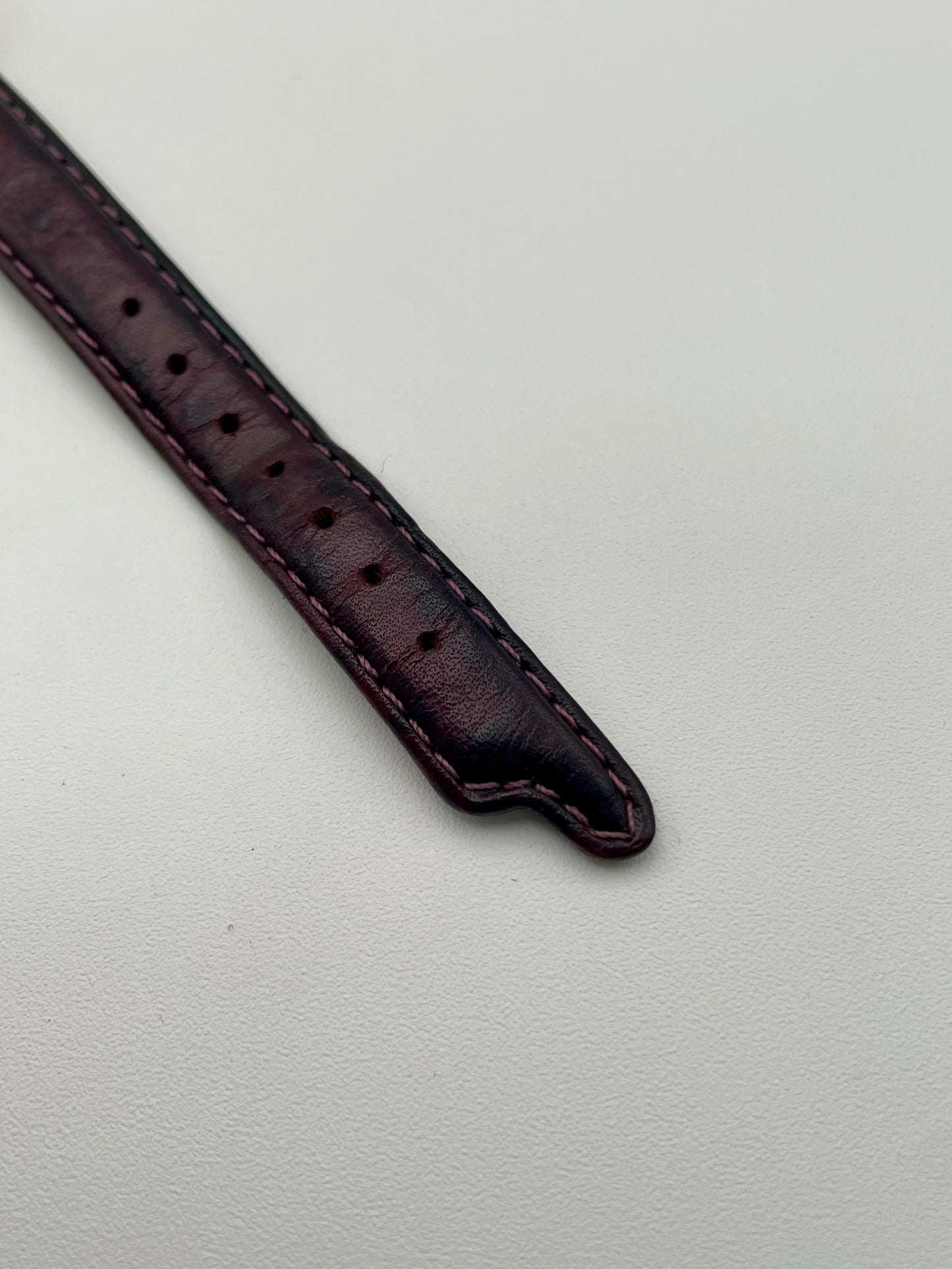 Close-up of the Exaequo Salvador Dali Softwatch vintage watch’s gold-tone buckle with a burgundy leather strap.