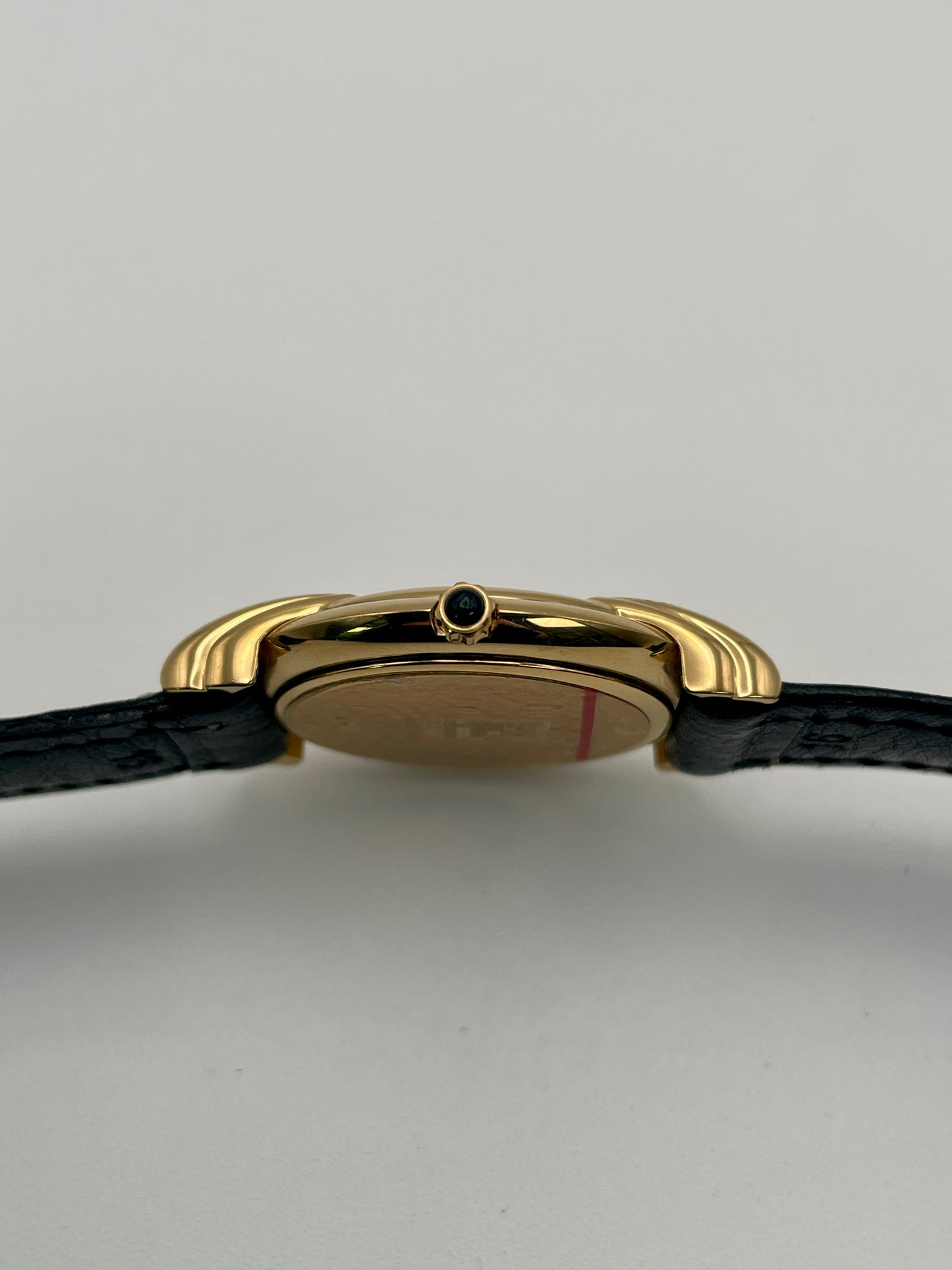 Close-up side view highlighting the small cabochon crown on the Fendi 300J gold case.