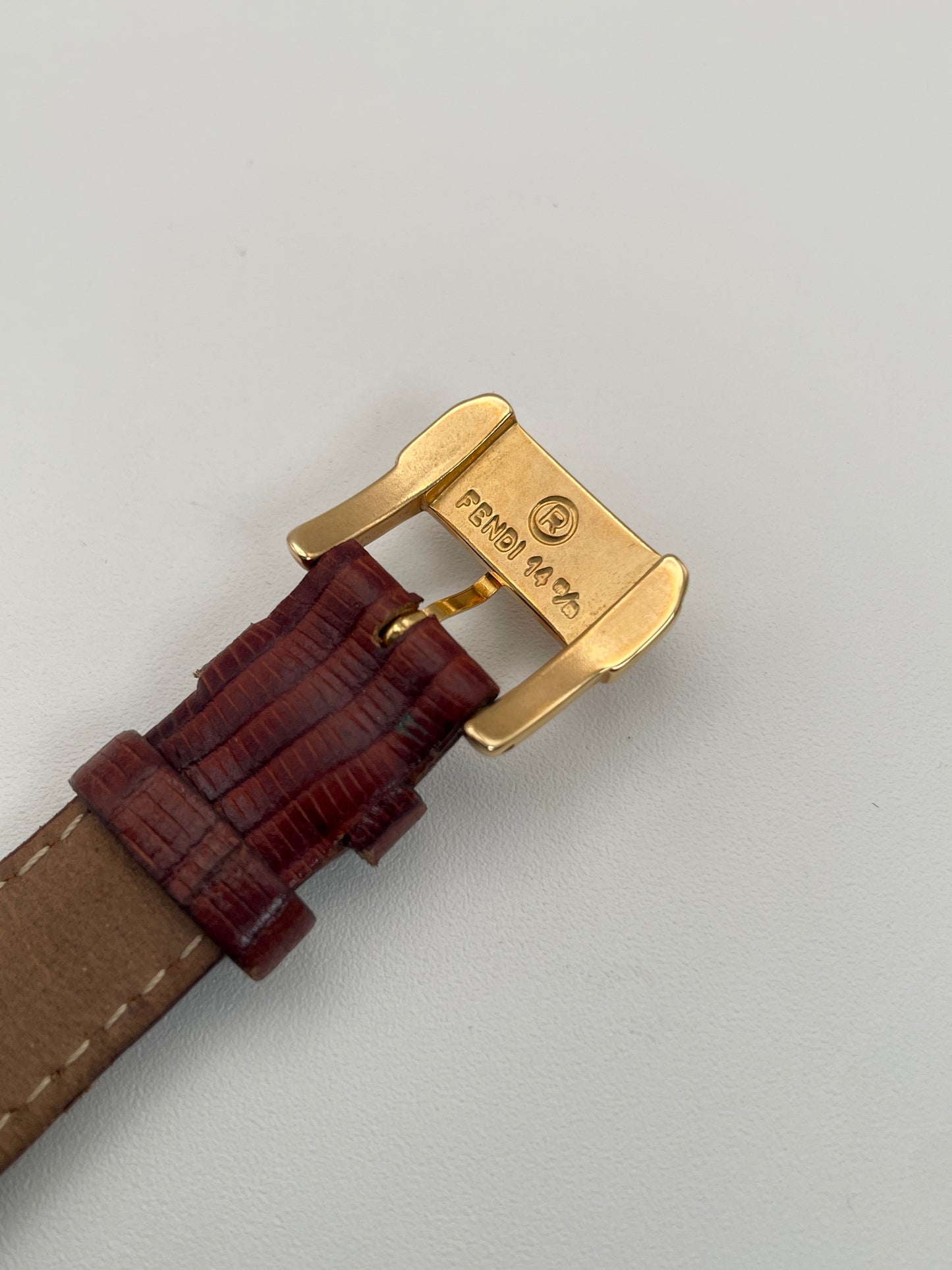 Close-up view of the Fendi-branded buckle on the red leather strap of the Fendi Orologi 410G watch.