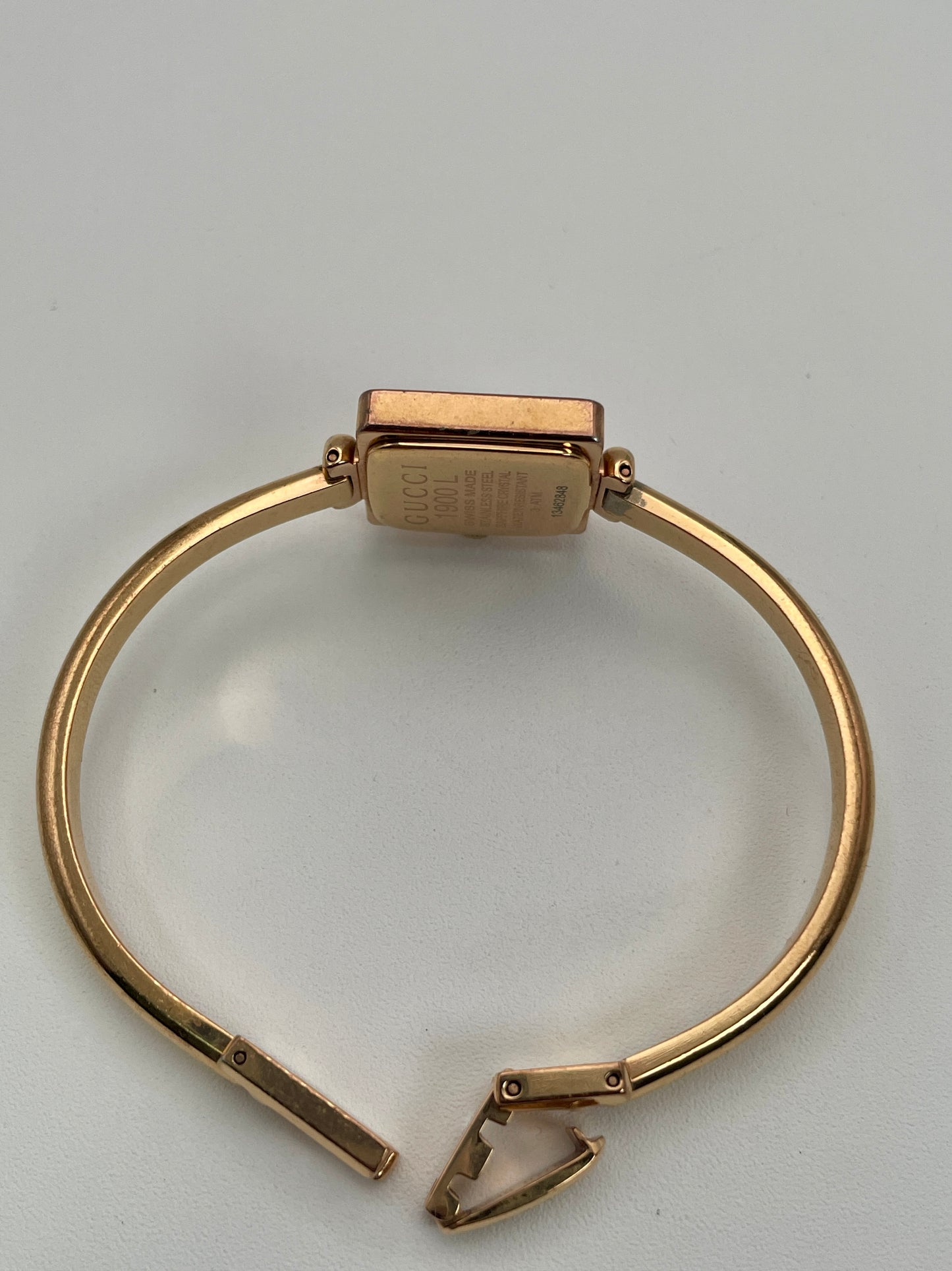 Back angled view of the Gucci 1900L vintage women's watch with its open bracelet and engraved caseback.