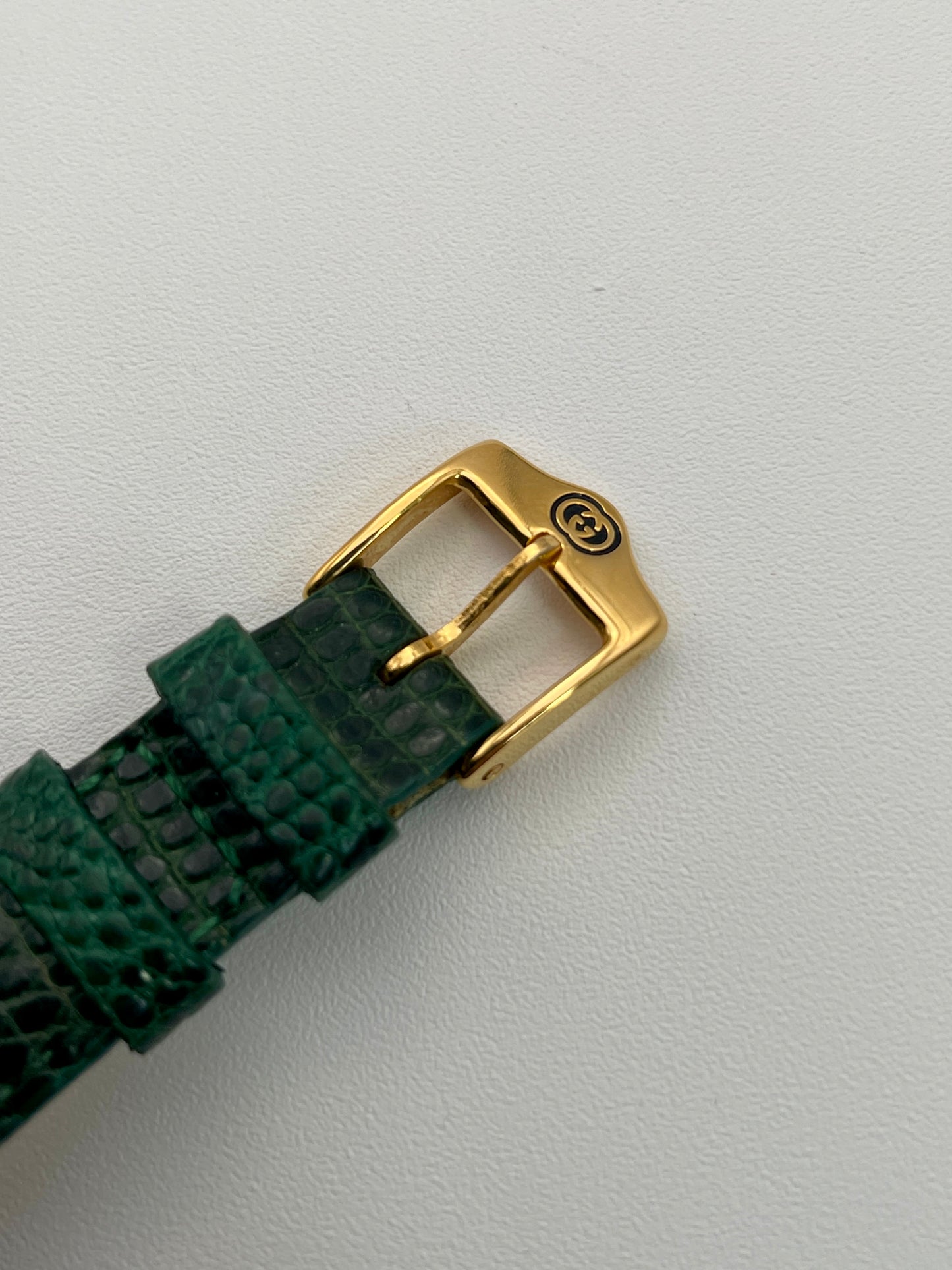 Close-up view of a Gucci 6300L ladies' watch, focusing on the gold buckle.