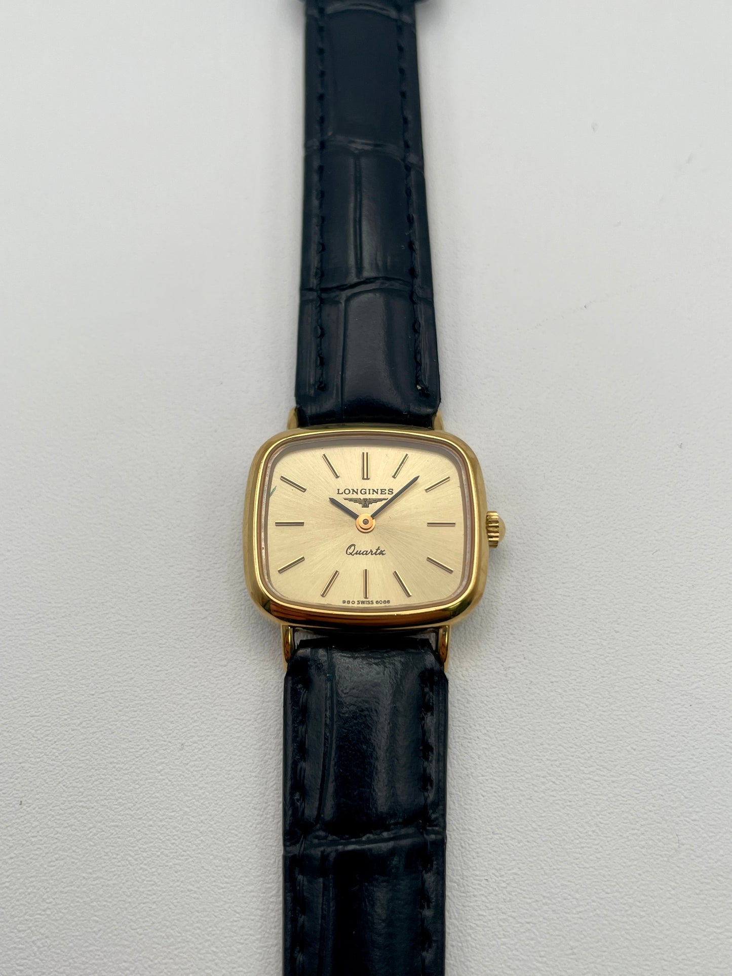 Longines 6068.2 vintage women's watch in gold-tone case with black leather strap, photographed flat from the front