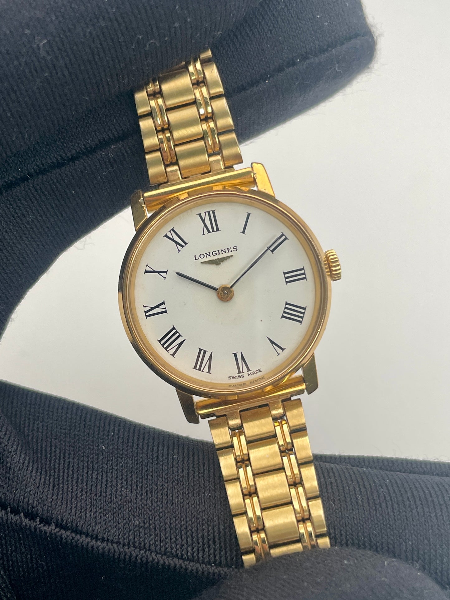 Close-up view of the Longines Classic Vintage Ladies Watch in Gold with Roman numerals, being held for display.