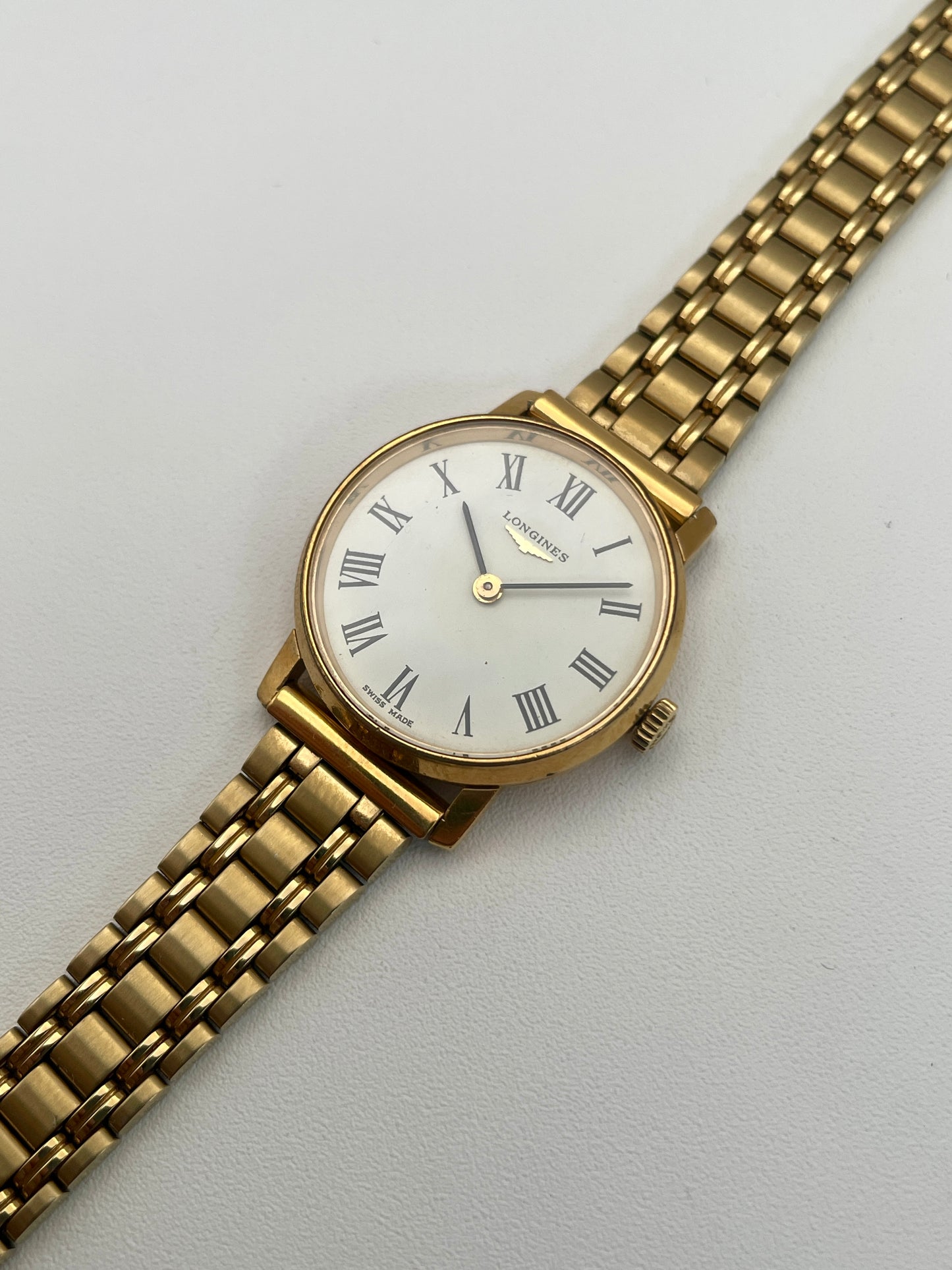 Diagonal view of the Longines Classic Vintage Ladies Watch in Gold with a white dial and black Roman numerals.