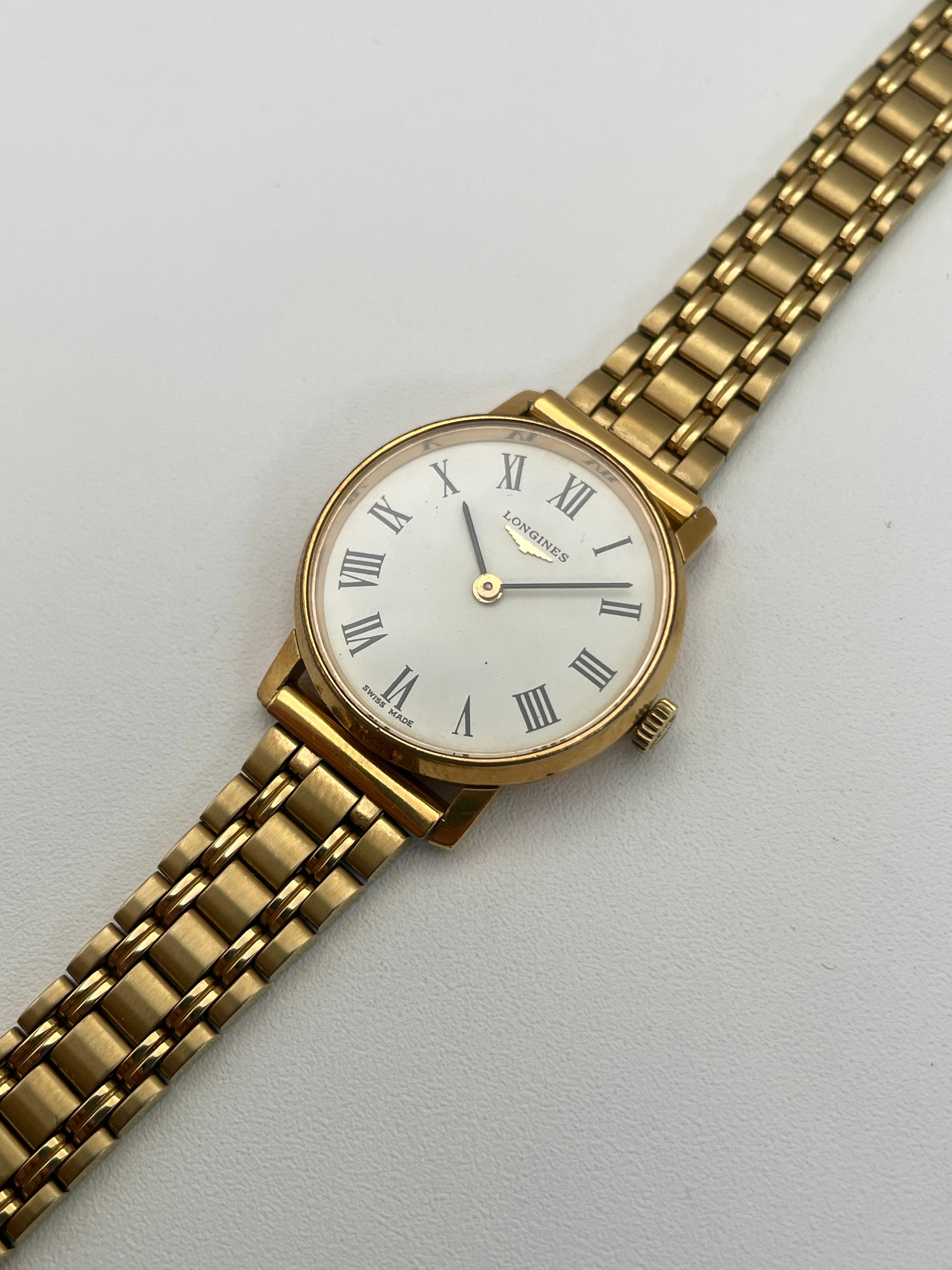 Diagonal view of the Longines Classic Vintage Ladies Watch in Gold with a white dial and black Roman numerals.