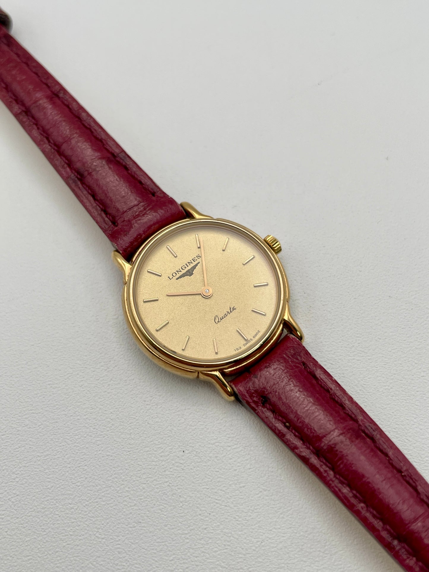 Diagonal left view of Longines L153.4 watch showing gold-tone case and champagne dial