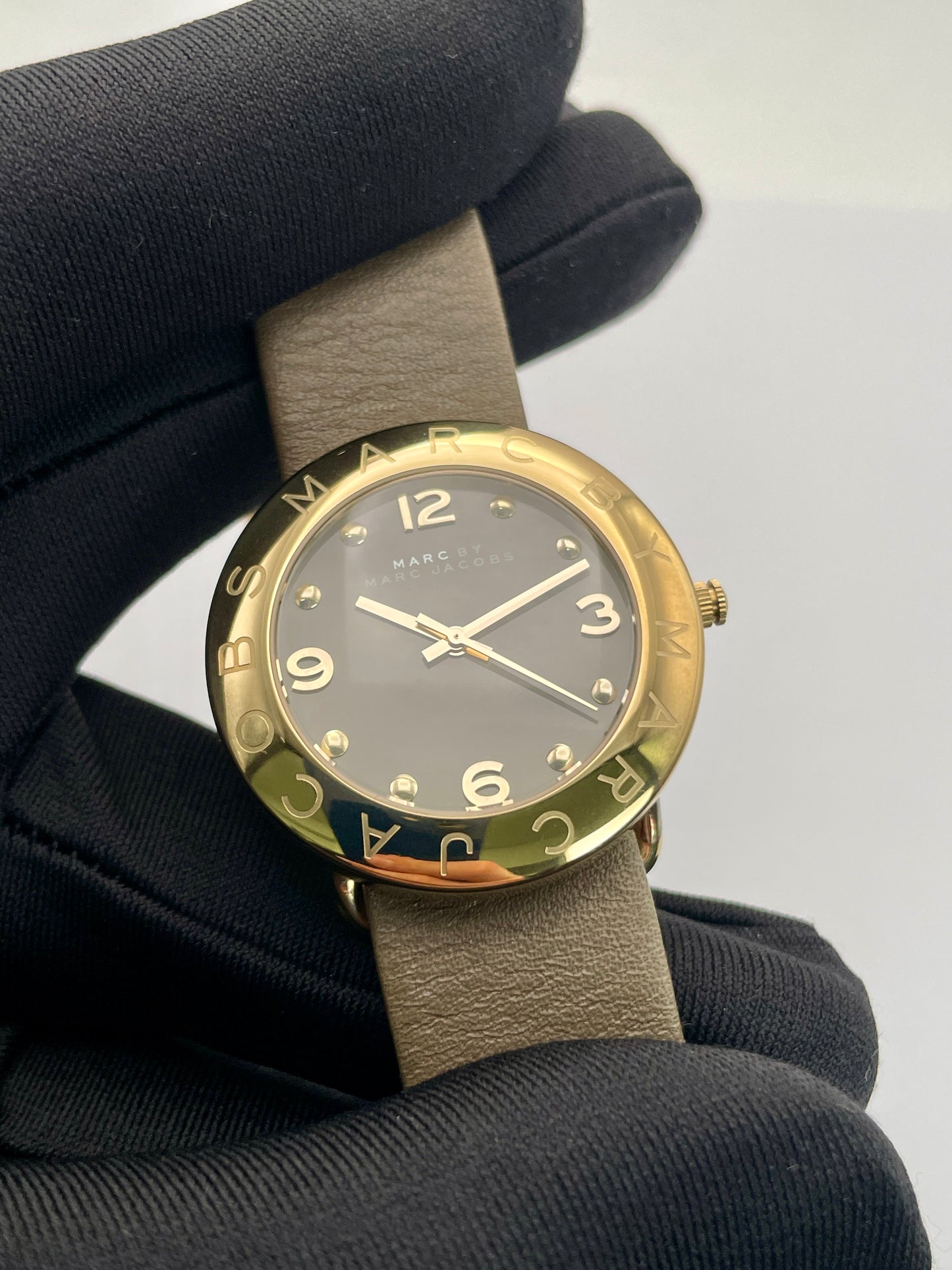 Close-up view of the Marc by Marc Jacobs watch face with gold-tone case and black dial