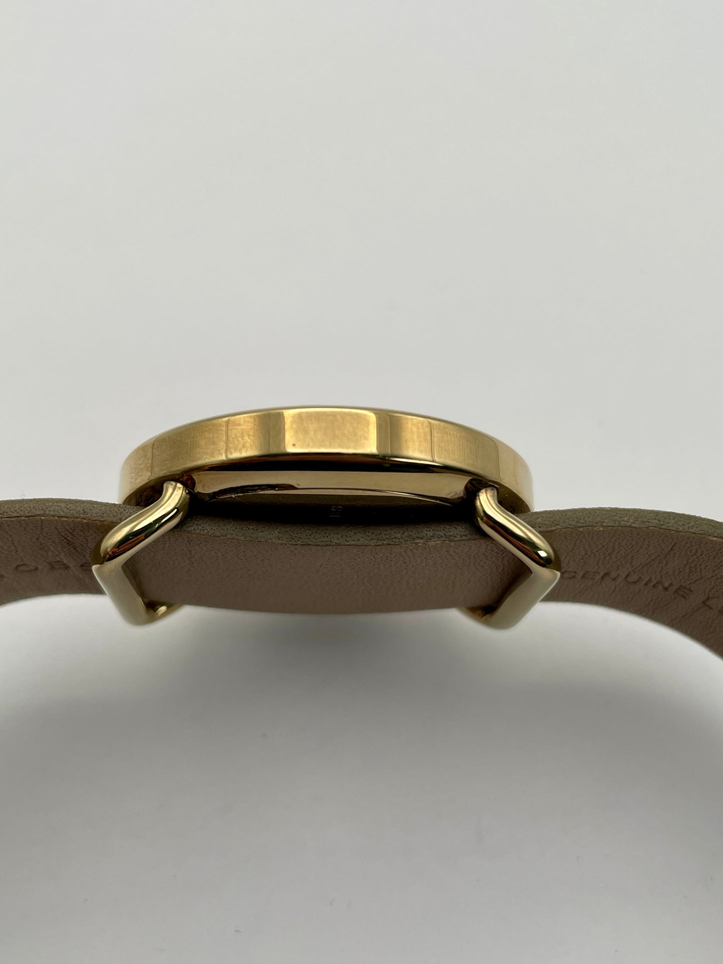 Side view of the Marc by Marc Jacobs watch showcasing the thickness of the gold-tone case and the tan leather strap