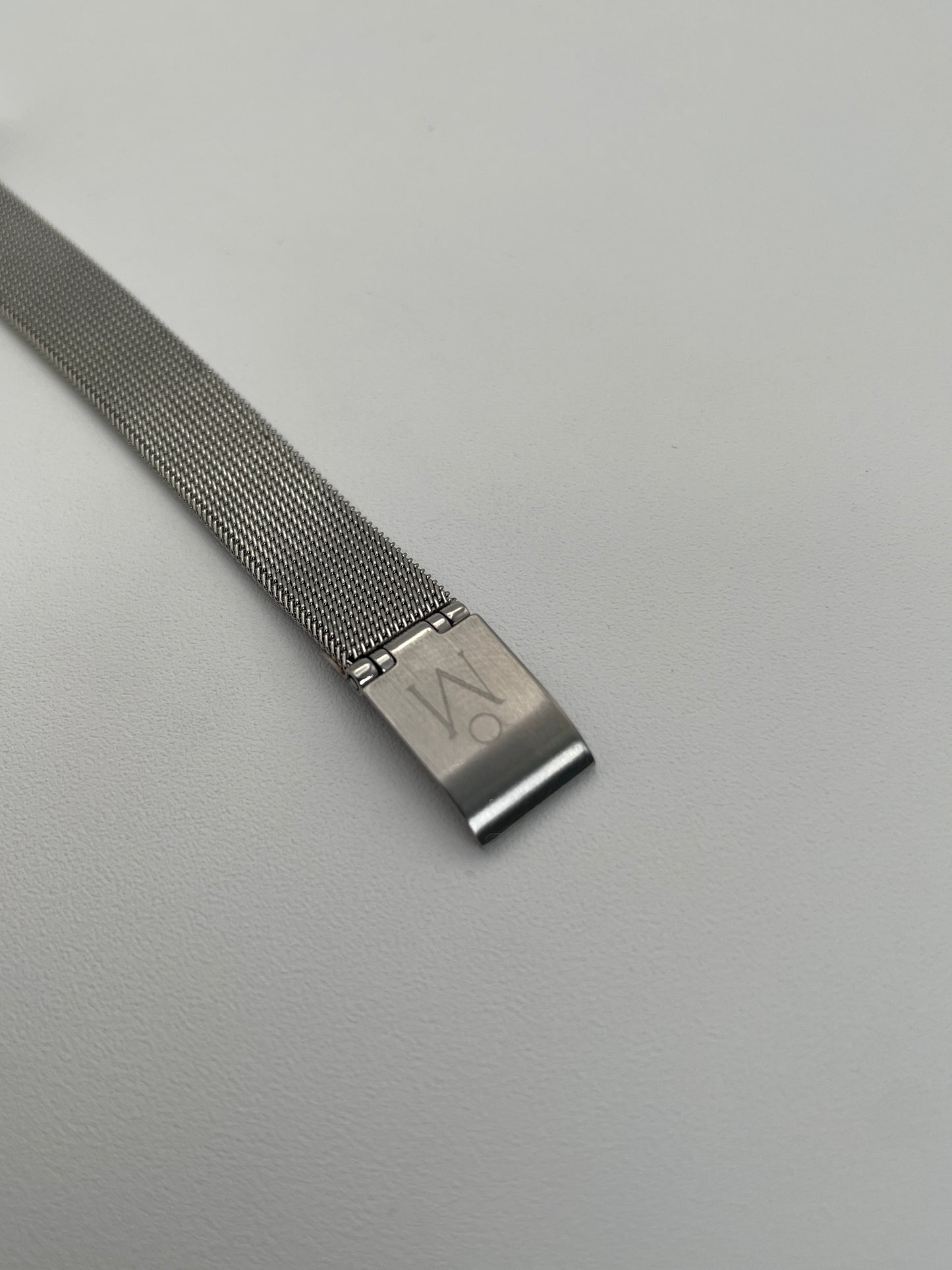 Close-up view of a Mikimoto ladies' watch, highlighting the detailed silver-tone case, the mesh bracelet, and the clasp featuring the brand's engraved logo.