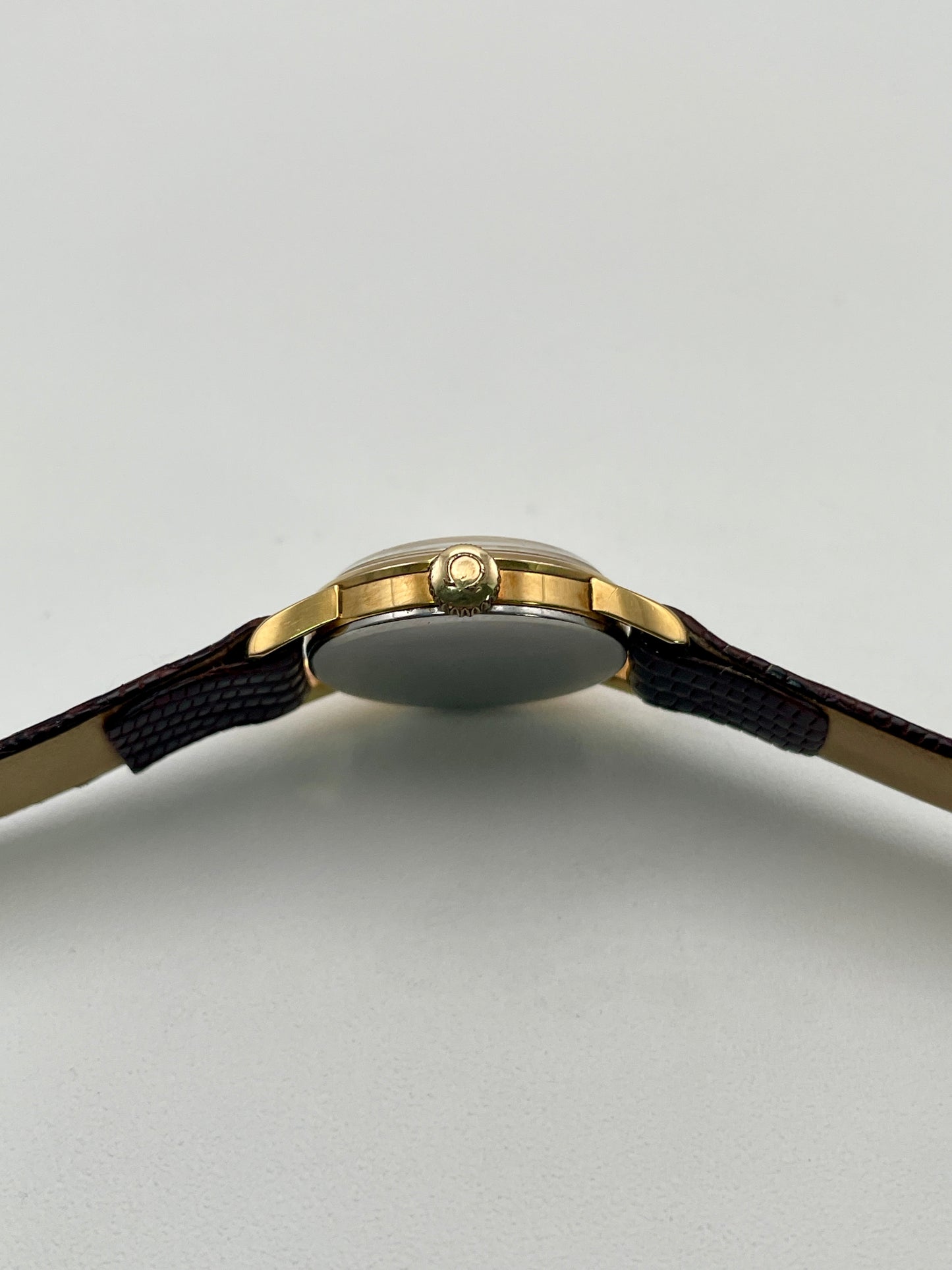 Crown view of an Omega 511.015 Vintage Women's Watch in gold, showing its smooth crown and polished case finish.