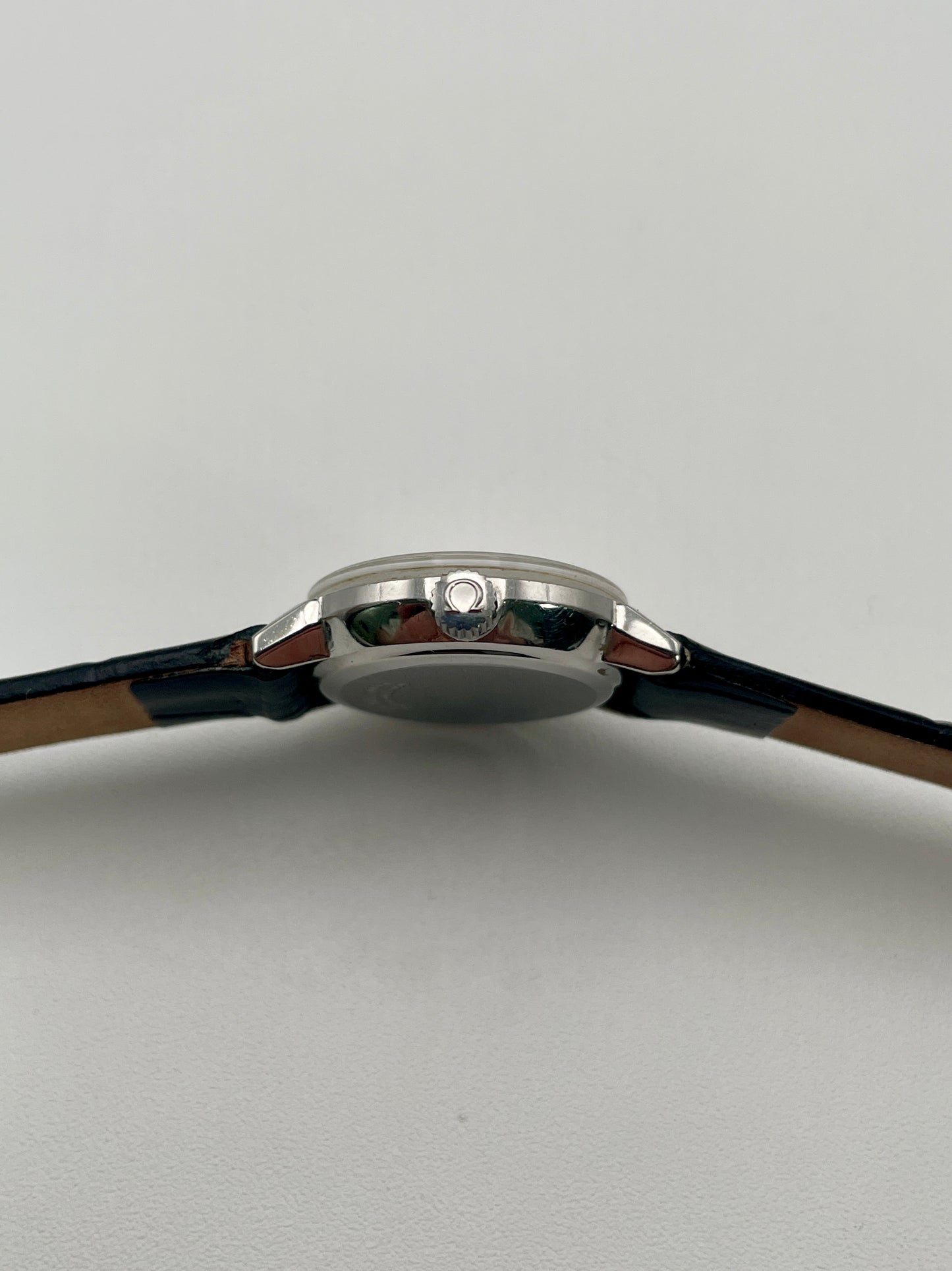 Side view of the Omega De Ville 515.007 vintage women's watch focusing on its polished stainless steel crown and case profile.
