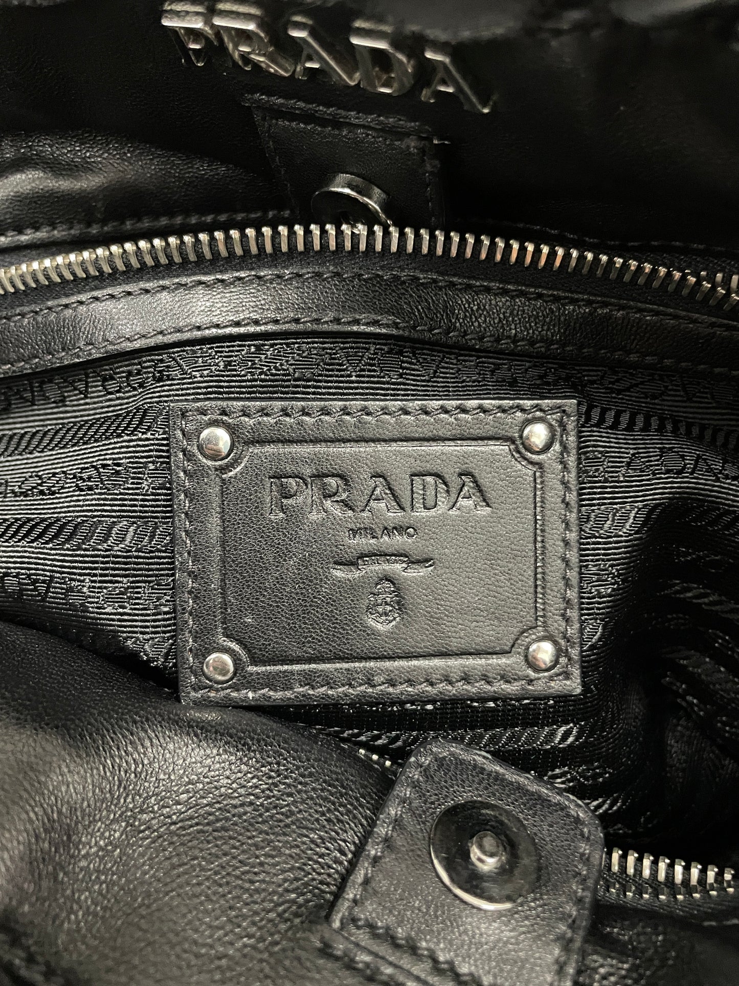 Close-up of the Prada logo on the interior of the Tessuto Ruffle Bag in black nylon with a branded lining.