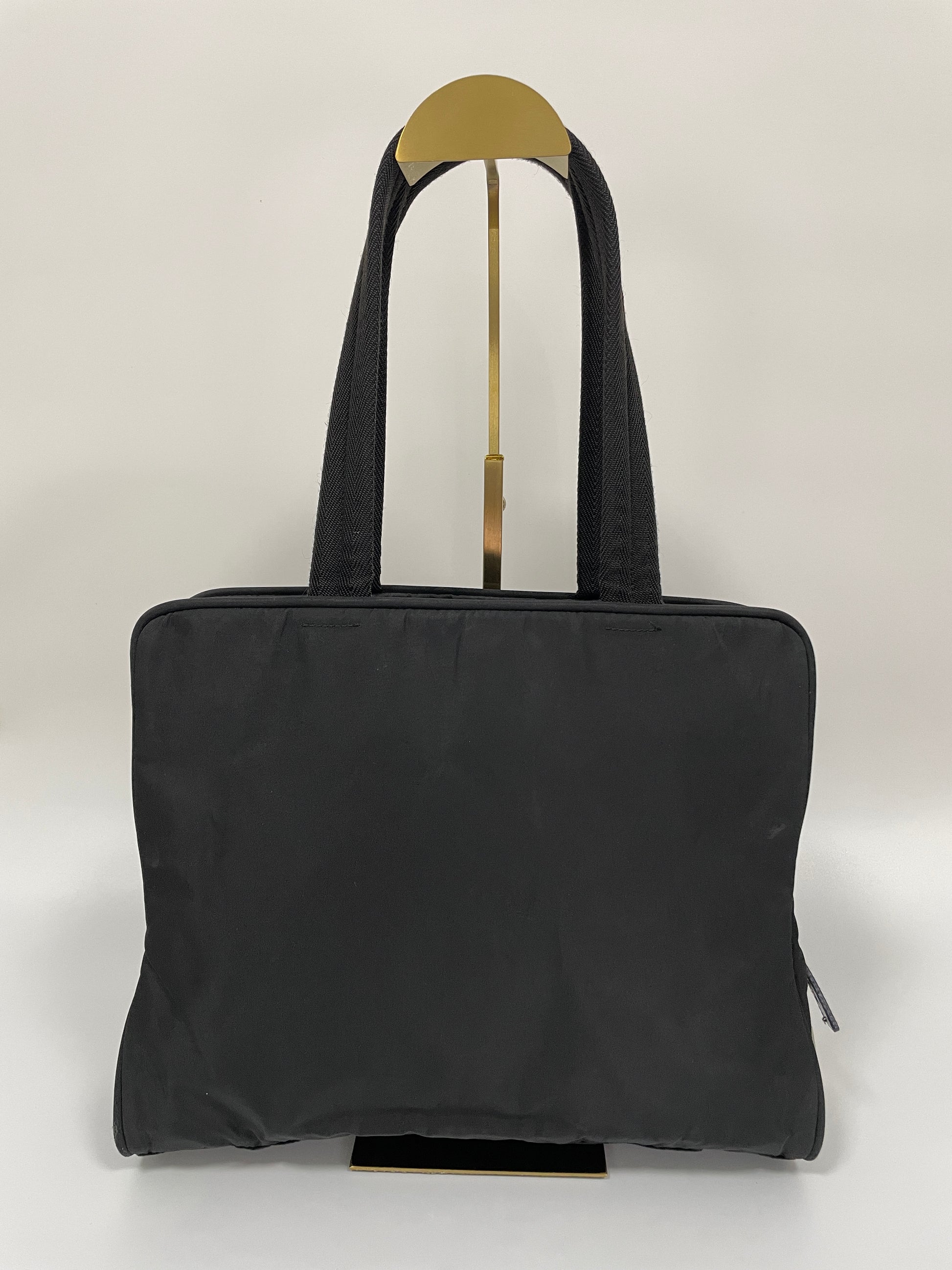 Back view of the Prada Tessuto Tote Bag in black nylon, showcasing its sleek, minimalist design.