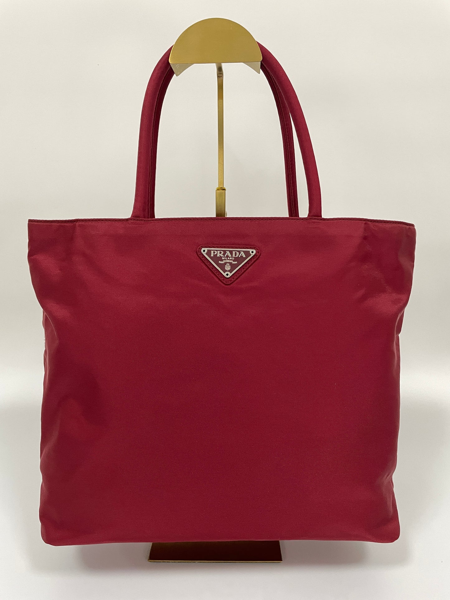 Front view of a Prada Tessuto Tote Bag in red nylon with dual handles and the Prada triangle logo.