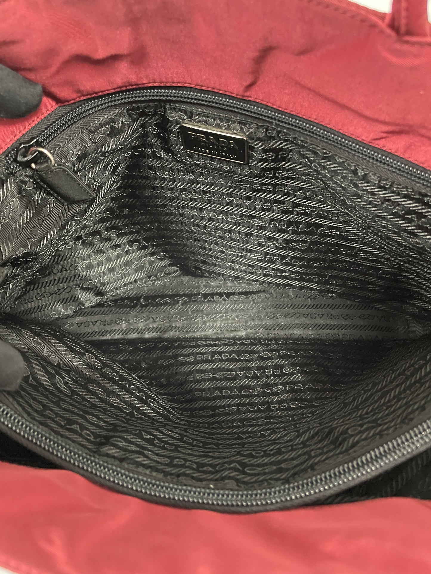 Interior view of the Prada Tessuto Tote Bag in red nylon displaying the spacious black fabric lining and zippered pocket.