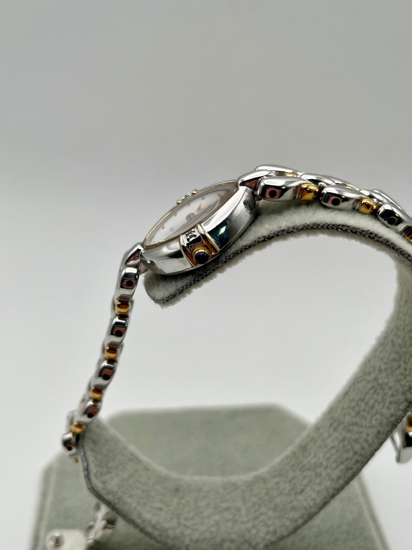 Side profile showing the gold-tone crown and diamond accent at the lug