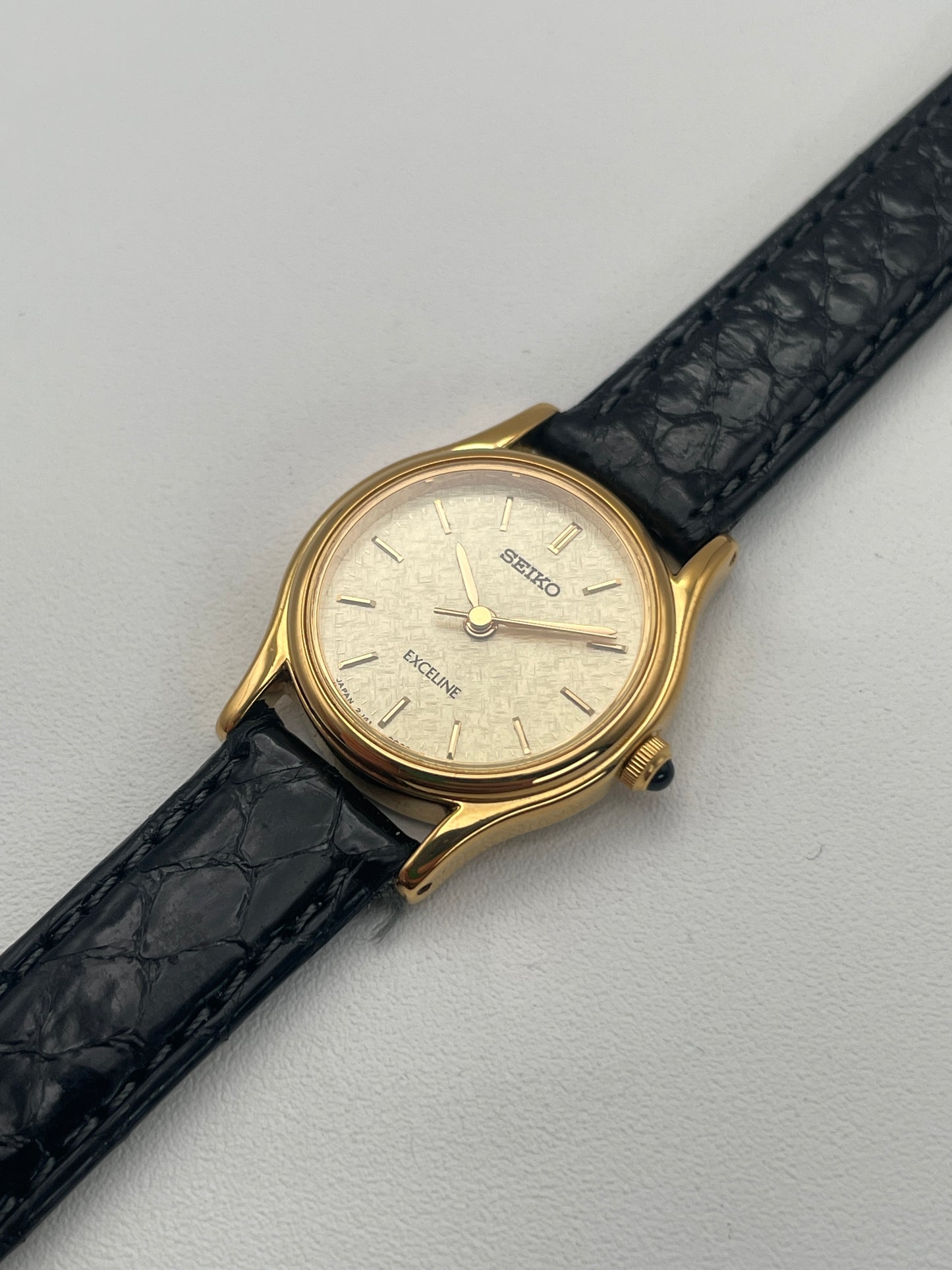 Diagonal view of Seiko Exceline gold watch showcasing the textured dial and sleek design.