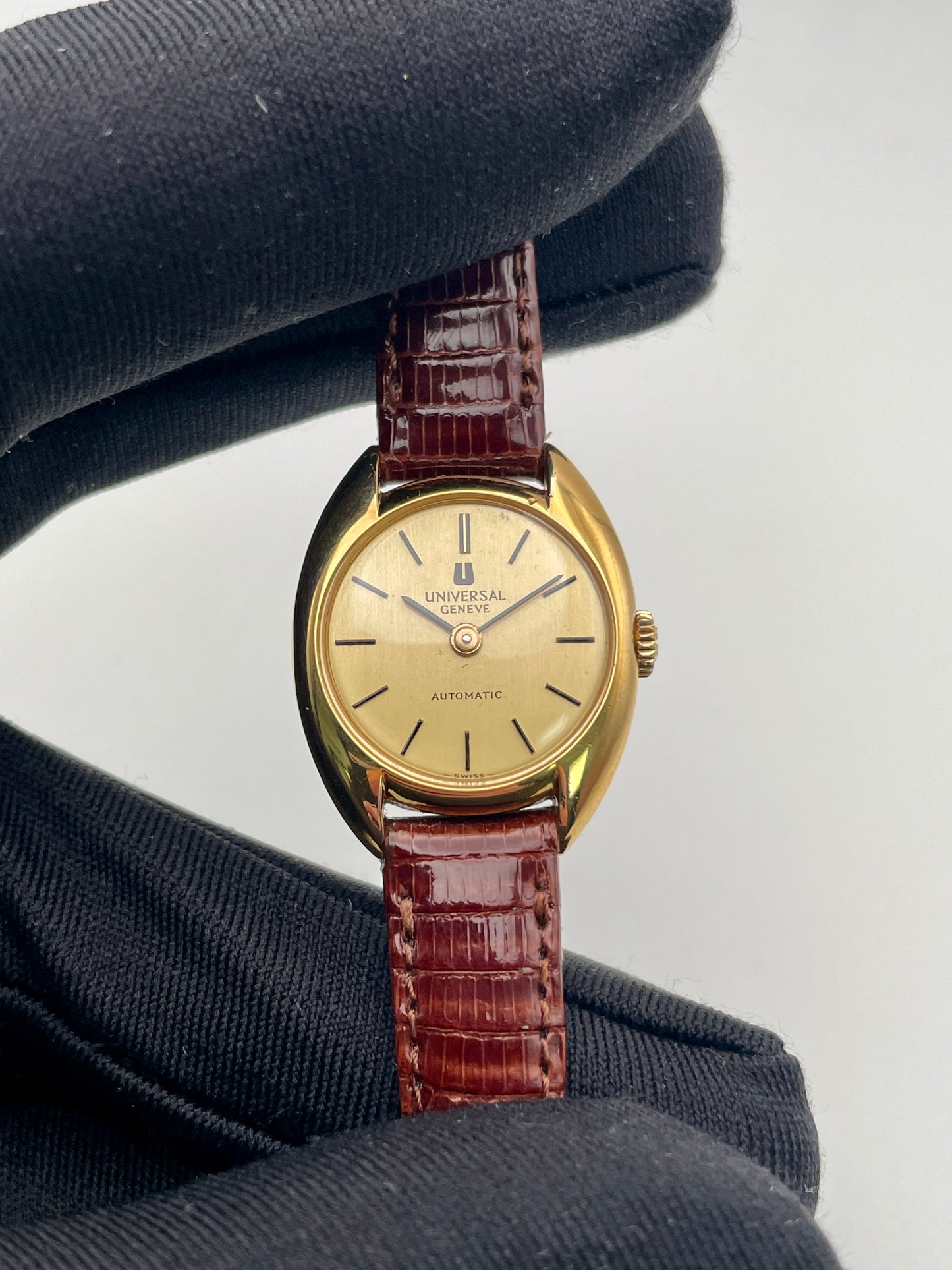 Close-up view of the Universal Geneve watch with gold case and champagne dial