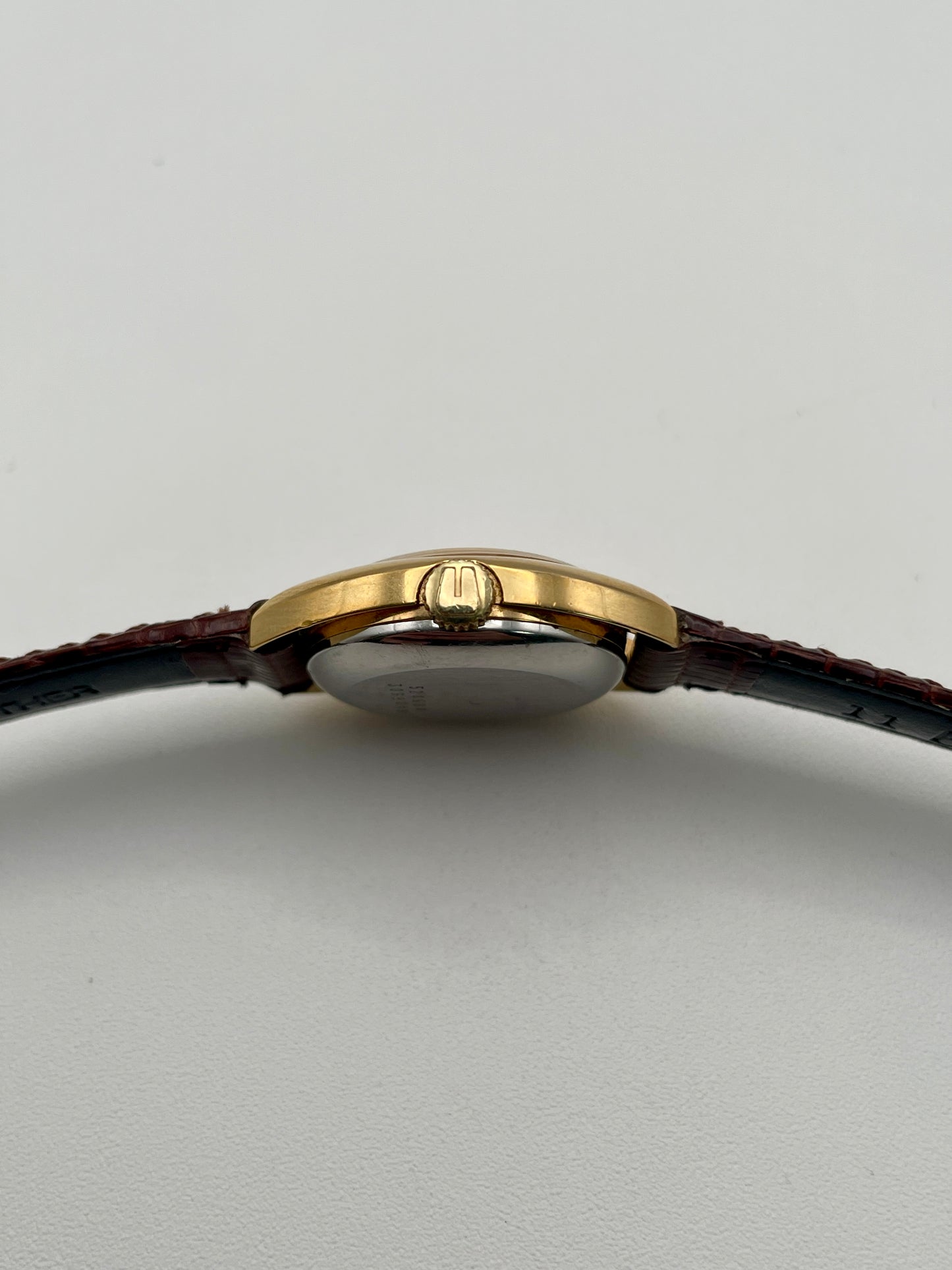 Crown side view showing signed crown of the Universal Geneve watch