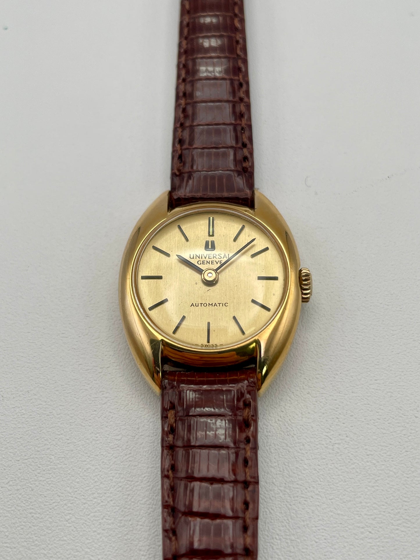 Front view of Universal Geneve vintage women's watch in gold with brown leather strap