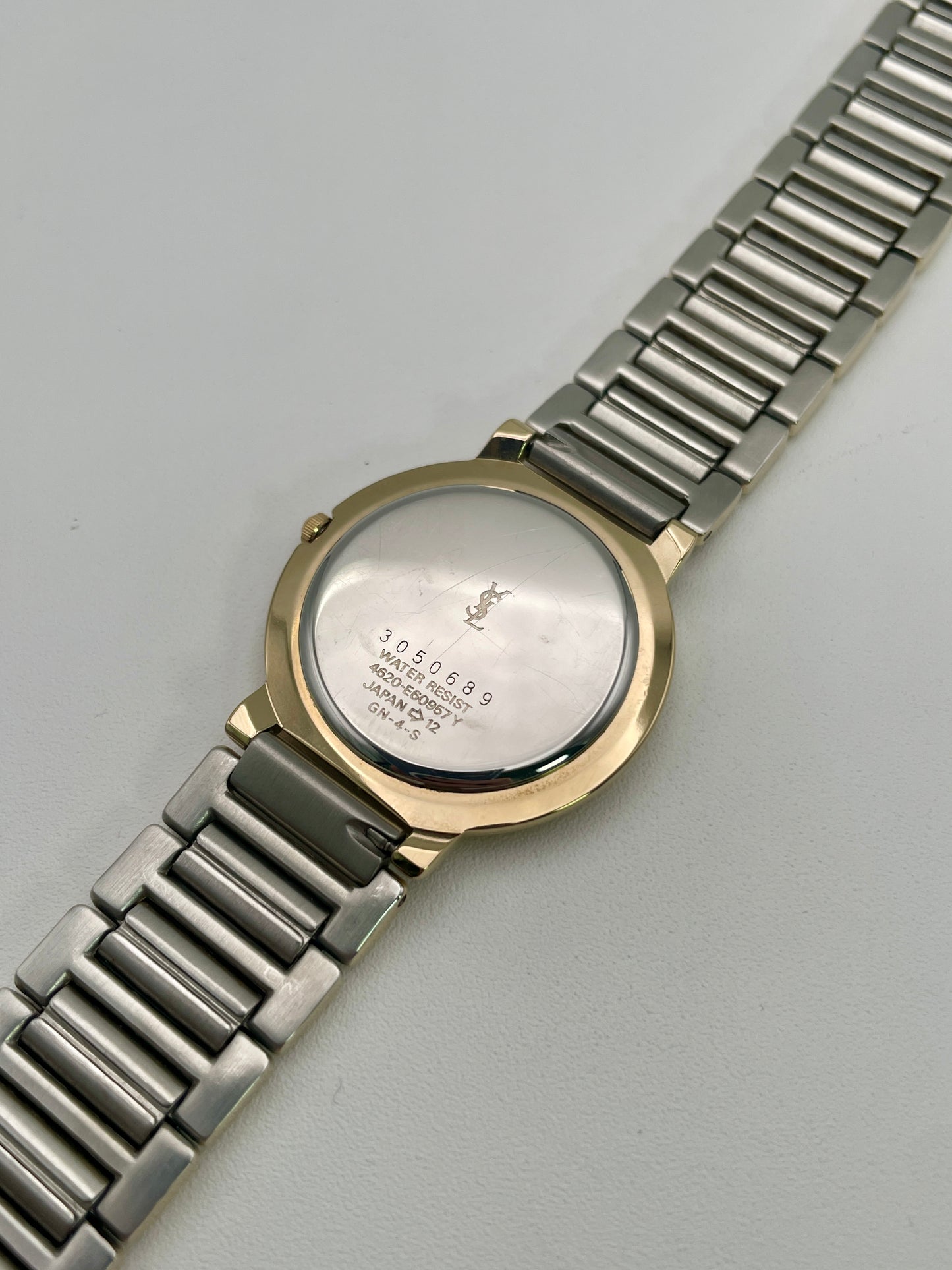 Caseback view of Yves Saint Laurent Pour Femme vintage watch, showing engraved YSL branding.
