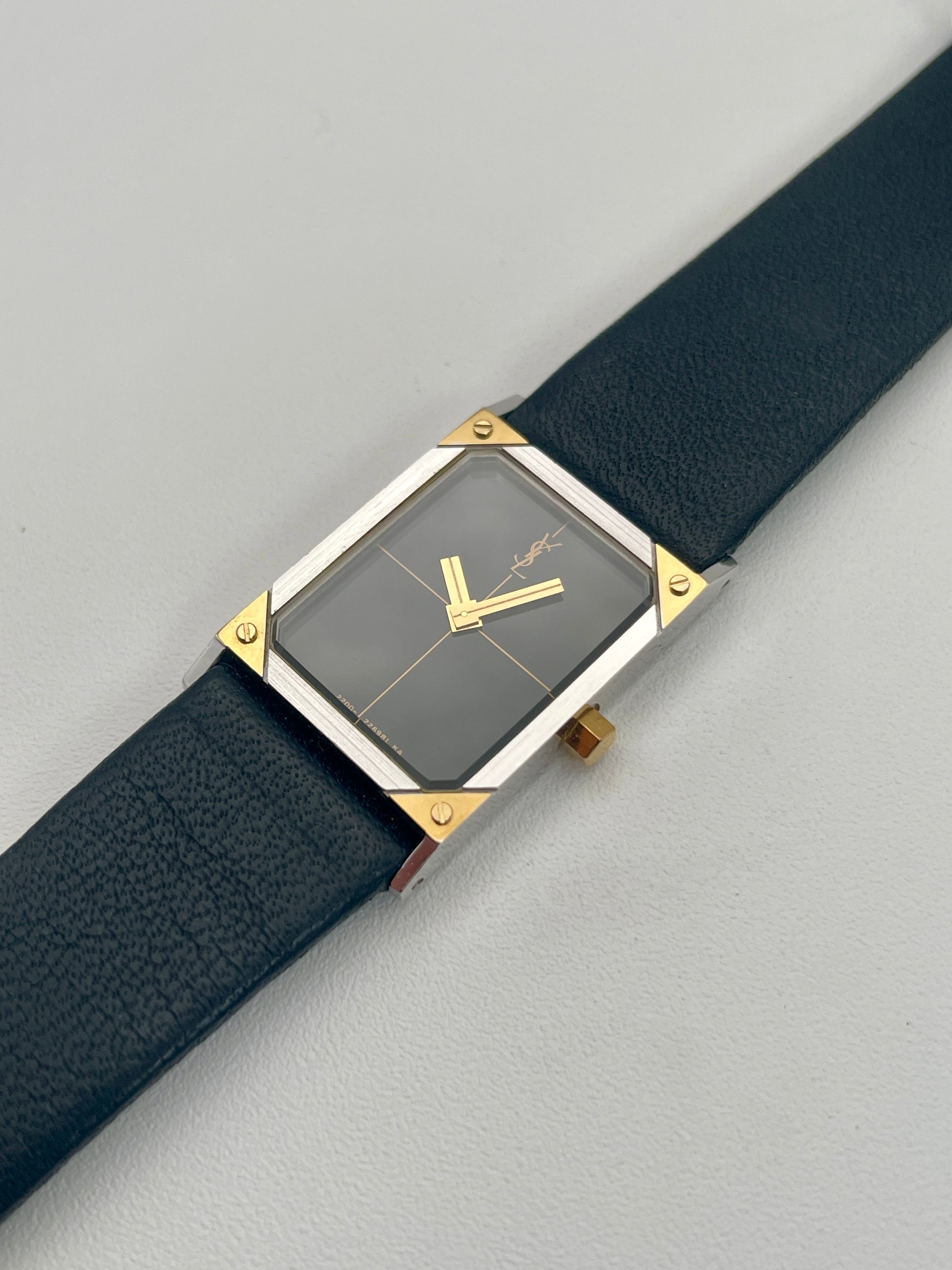 Angled view of Yves Saint Laurent vintage women's watch showcasing the steel and gold case with screw details.