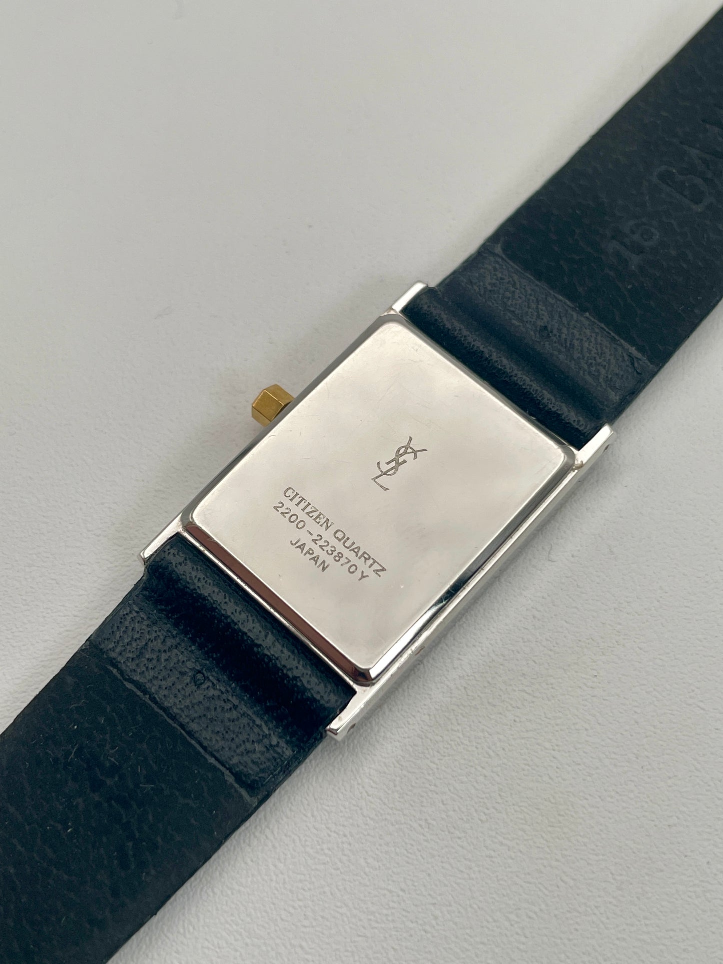 Caseback of Yves Saint Laurent vintage women's watch displaying engraved details.