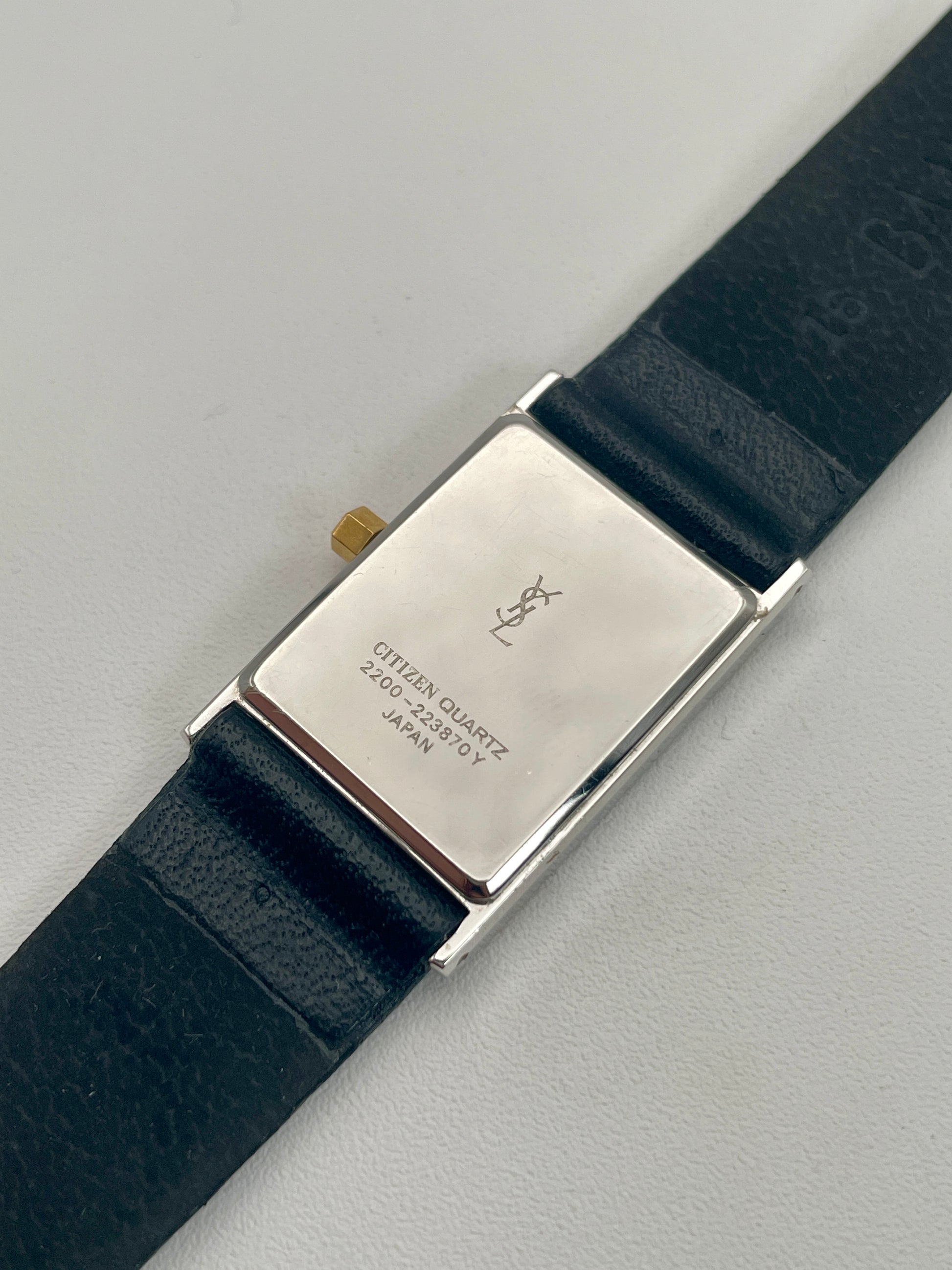 Caseback of Yves Saint Laurent vintage women's watch displaying engraved details.