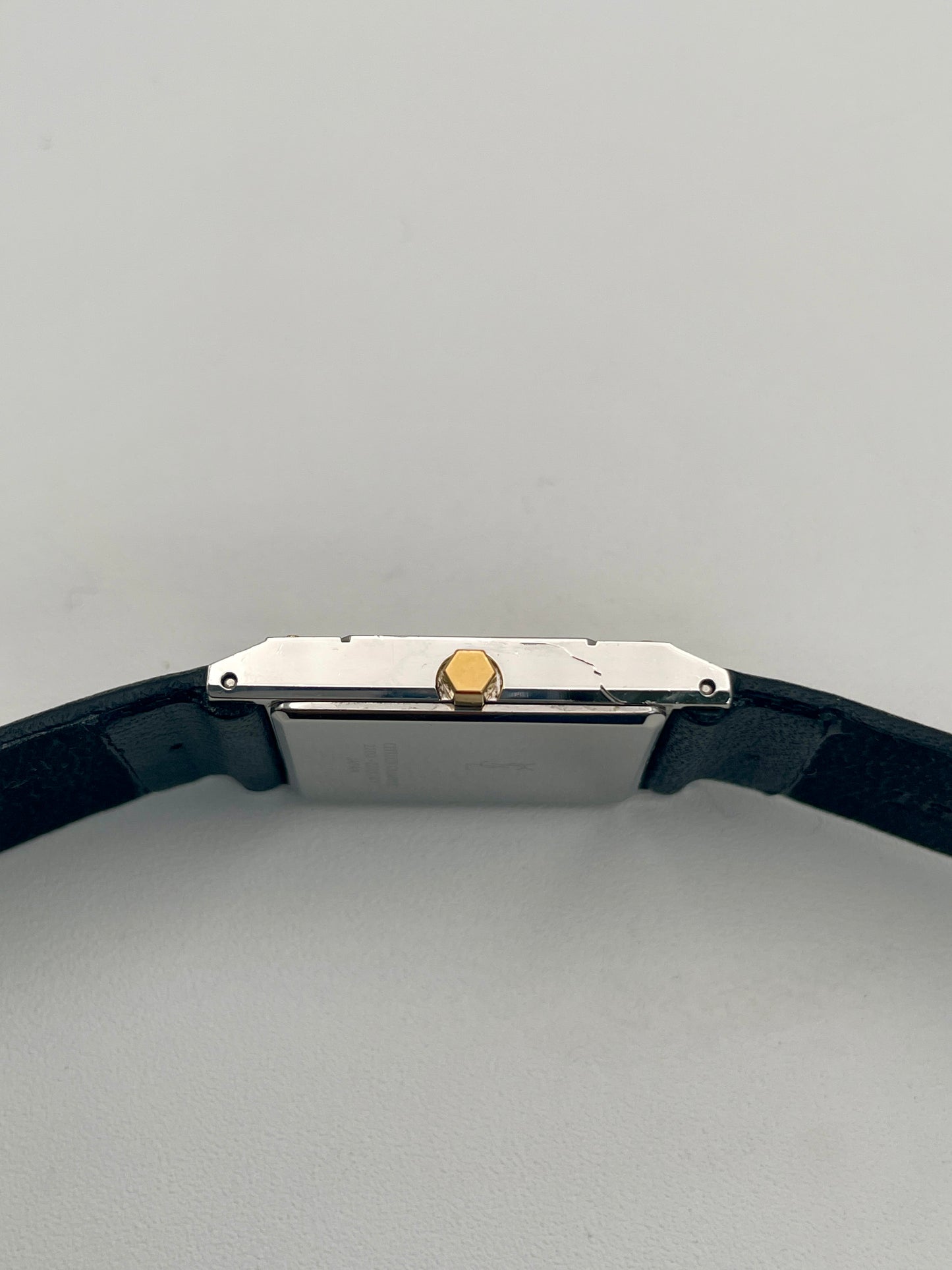 Crown side view of Yves Saint Laurent vintage women's watch highlighting the thin rectangular case and gold accent crown.