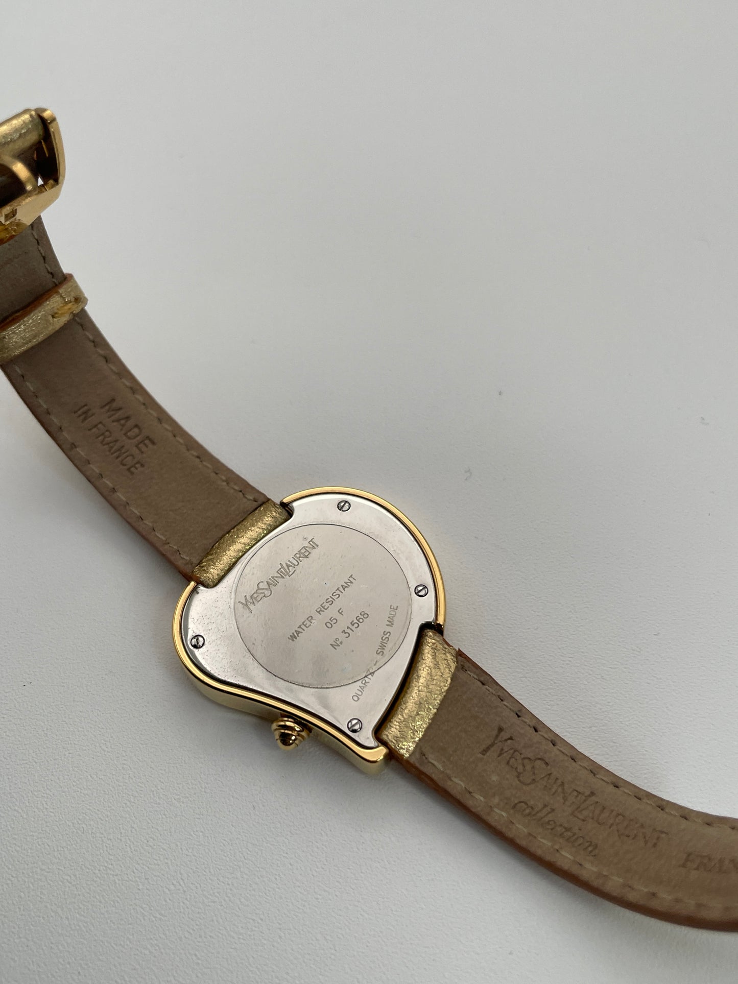 Caseback view of the Yves Saint Laurent YSL Heart Watch in medium size, showing the engraved case back and gold leather strap.