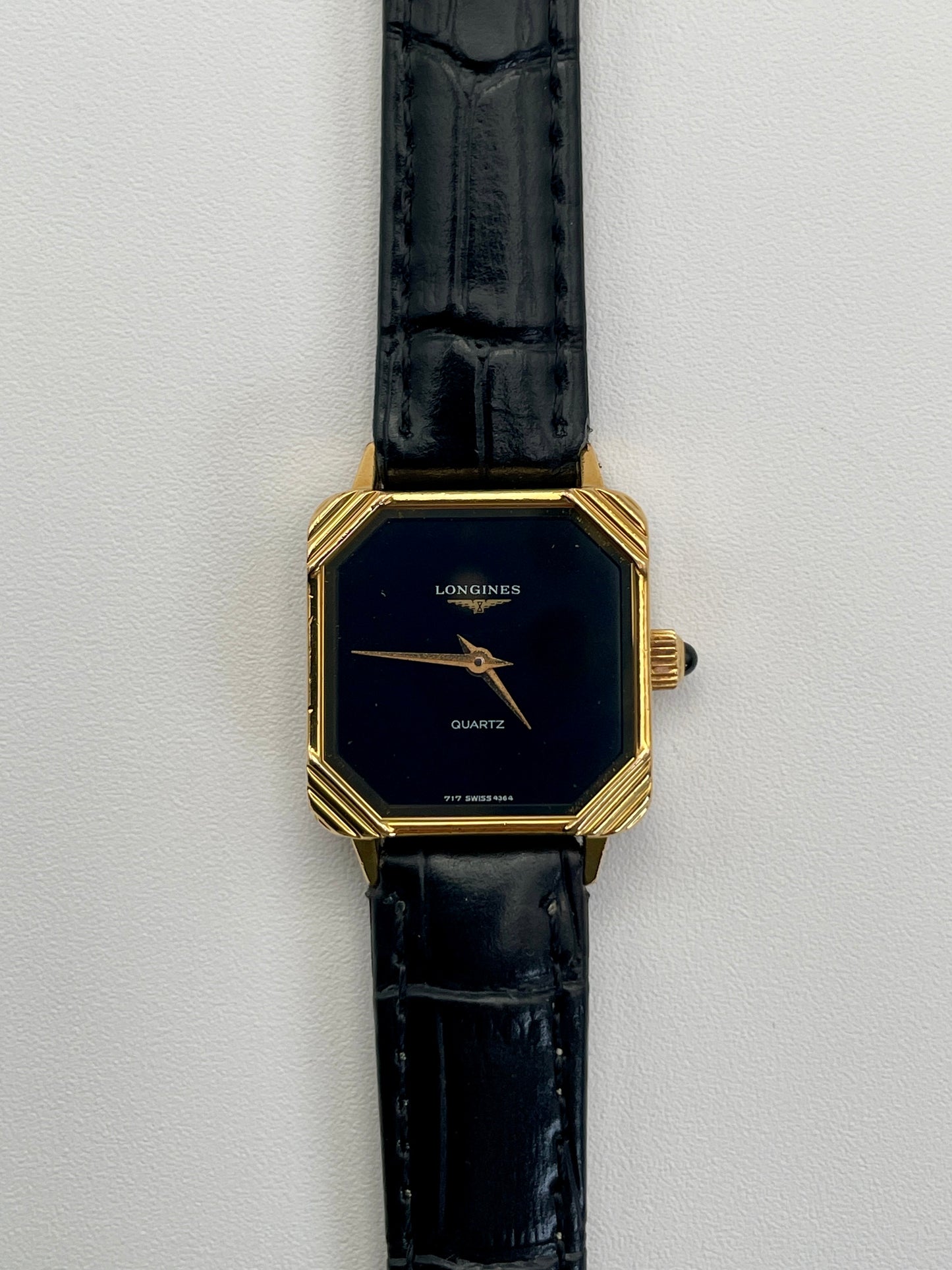 Front view of Longines Neo-Vintage Quartz watch with gold case, black dial, and black leather strap.