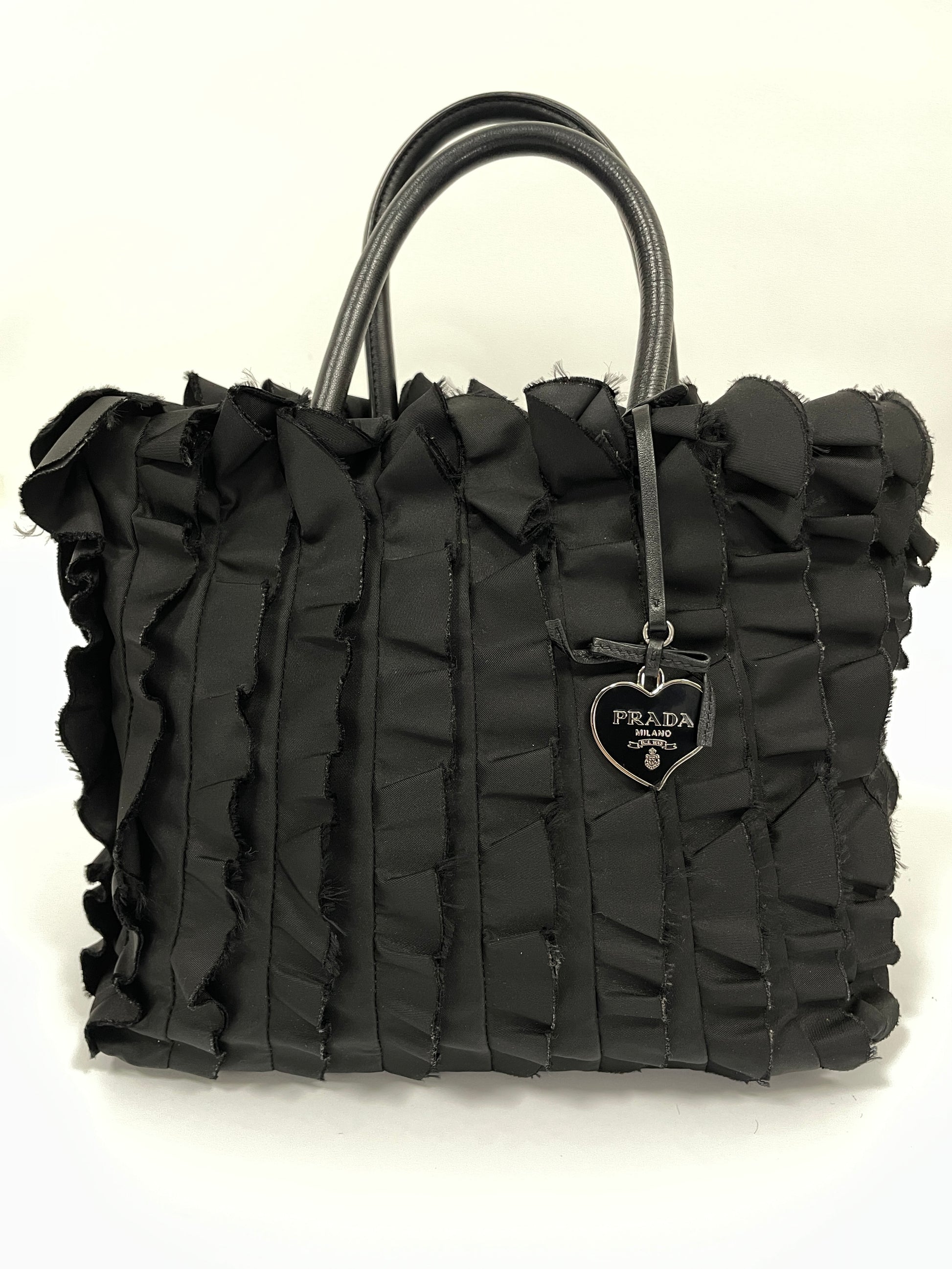 Full front view of Prada Tessuto Ruffle Bag in black nylon with its signature ruffles and black leather handles.