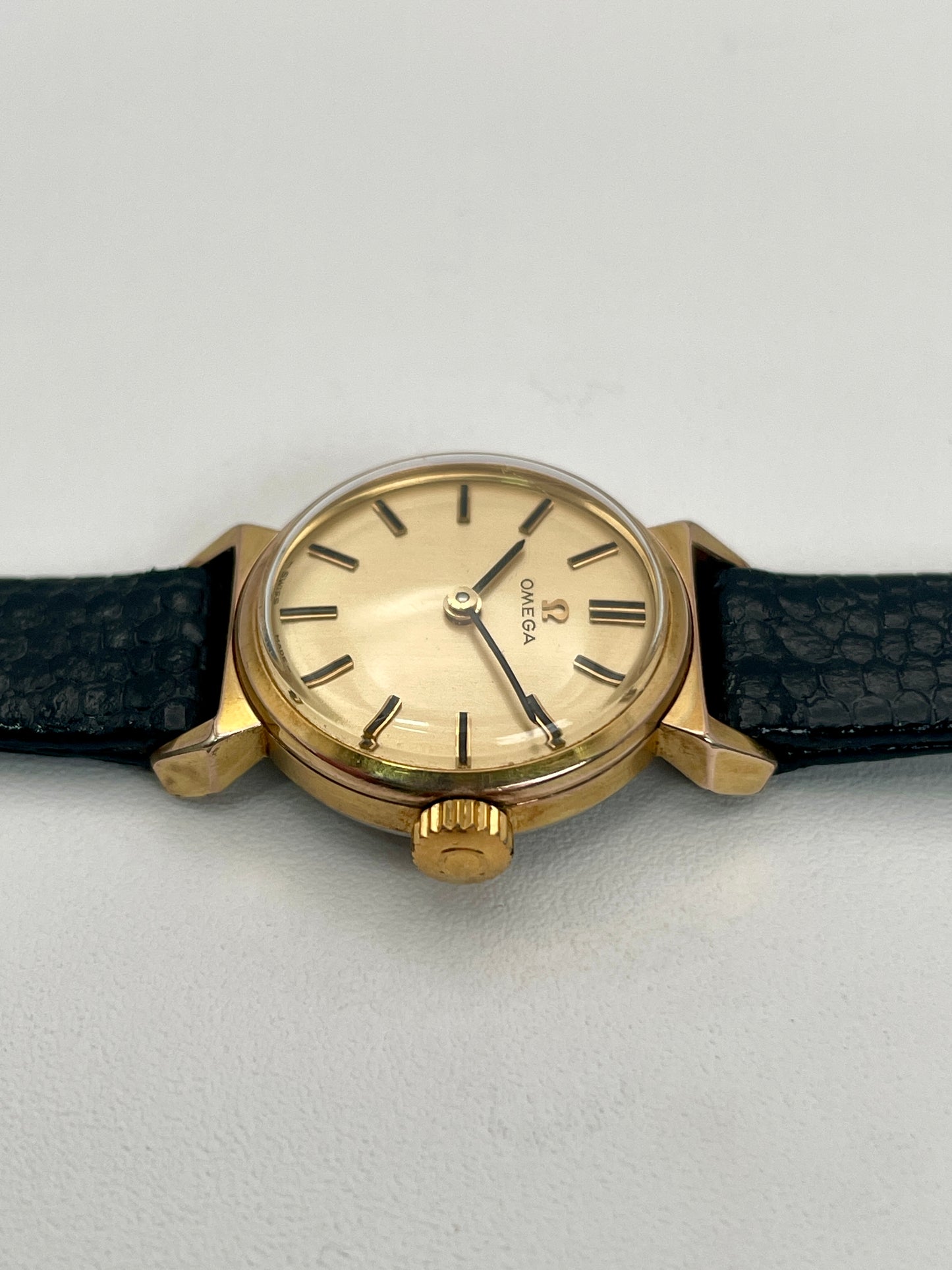 Close-up of the Omega Art Deco vintage gold ladies watch showing crown and textured case.