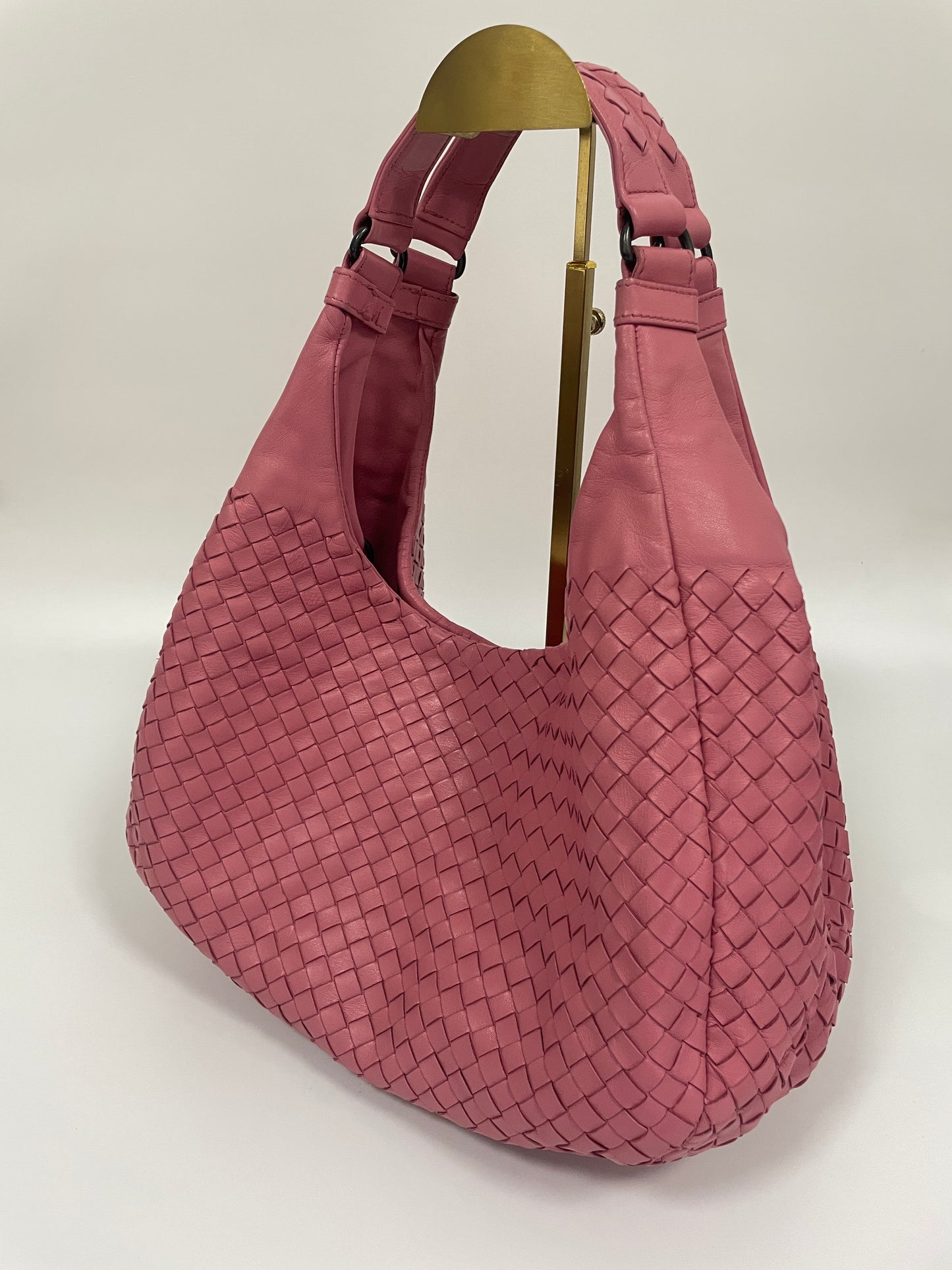 Side-angle view of the Bottega Veneta Intrecciato Campana Shoulder Bag in pink woven leather, highlighting the bag's structure and smooth leather finish.