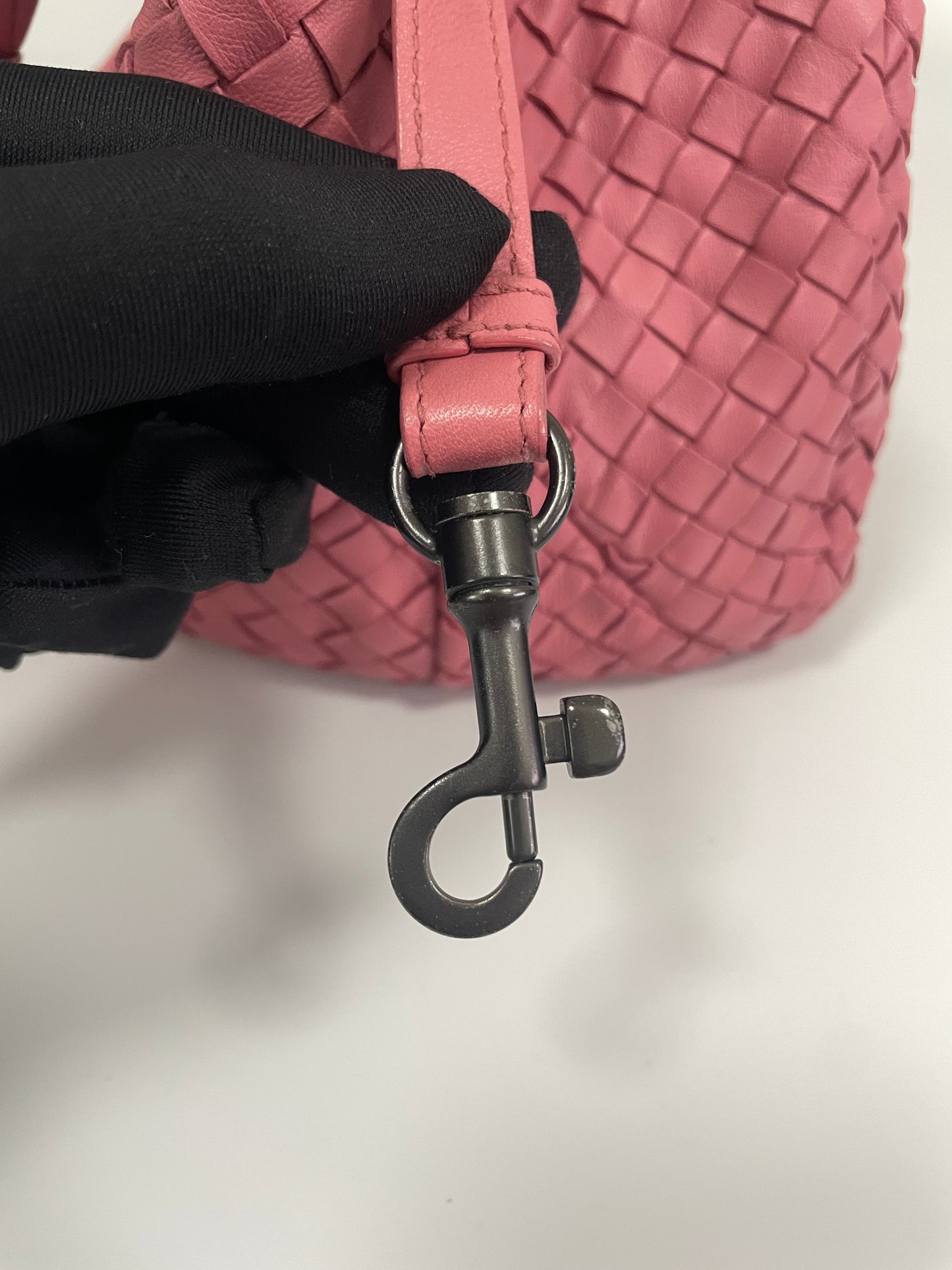 Detailed view of the clasp on the Bottega Veneta Intrecciato Campana Shoulder Bag, featuring the pink leather strap and metal hardware.