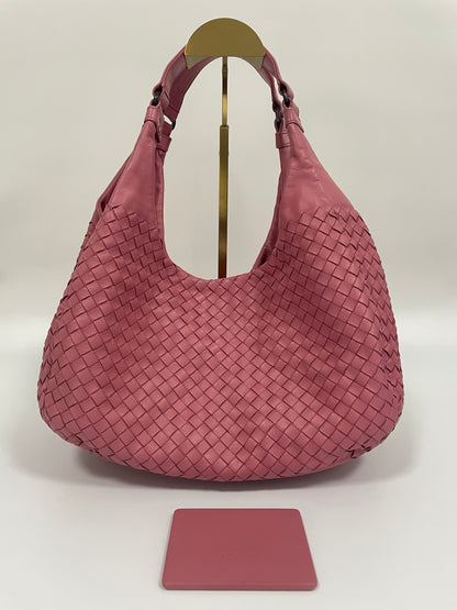 Front view of the Bottega Veneta Intrecciato Campana Shoulder Bag in pink woven leather, showing the iconic intrecciato pattern and includes the Bottega Veneta Mirror backside.