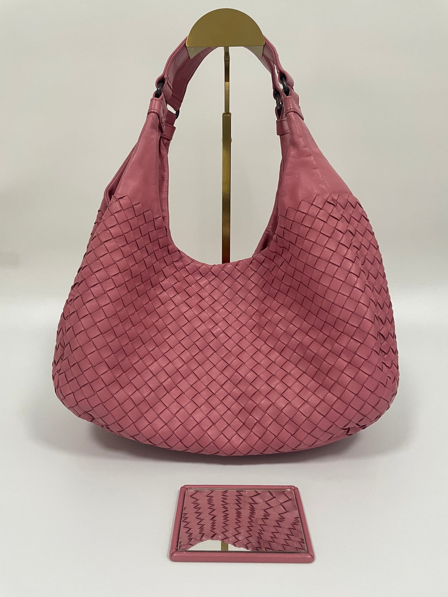 Front view of the Bottega Veneta Intrecciato Campana Shoulder Bag in pink woven leather, showing the iconic intrecciato pattern and includes the Bottega pocket mirror.