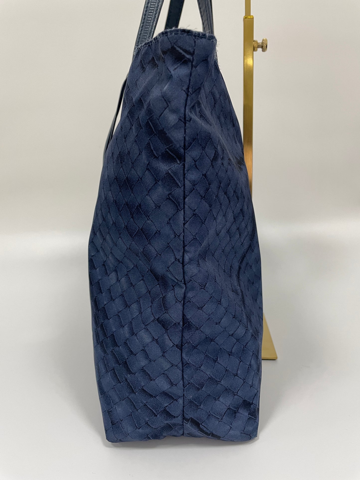 Side view of a Bottega Veneta Intrecciolusion Mirage Butterfly Tote Bag in blue, highlighting the intrecciato texture and structured shape.