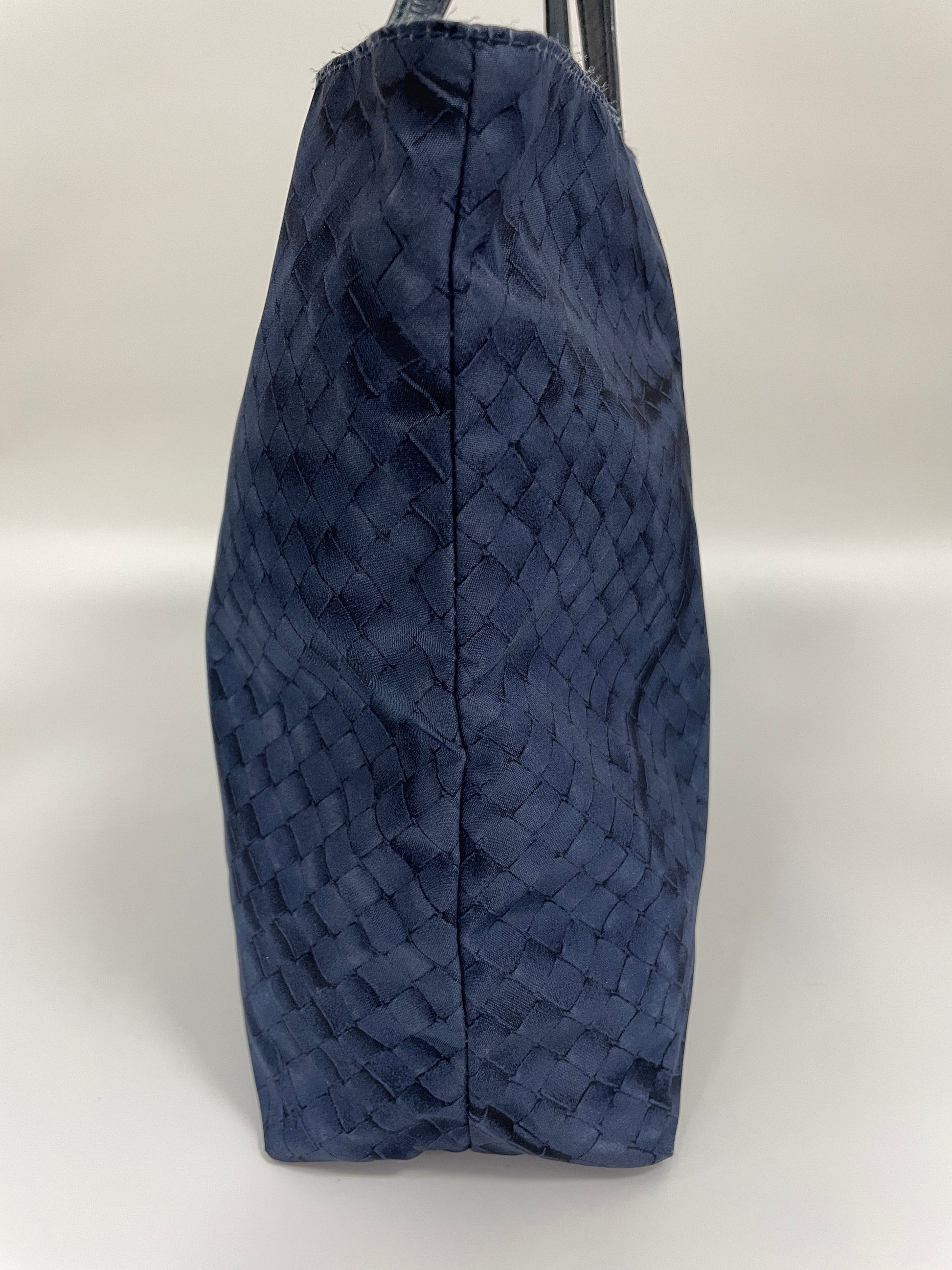 Side view of a Bottega Veneta Intrecciolusion Mirage Butterfly Tote Bag in blue, highlighting the intrecciato texture and structured shape.