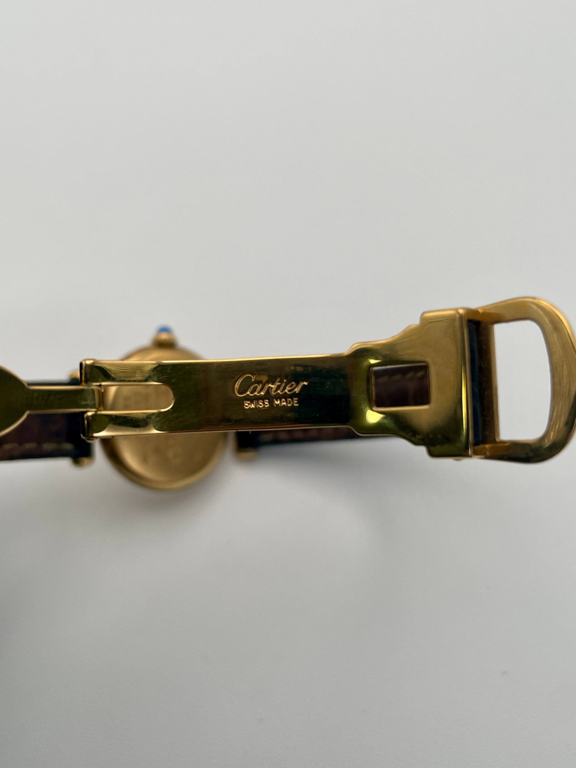 Clasp view of Cartier Colisée Vermeil watch with an engraved Cartier logo on the gold-tone buckle.